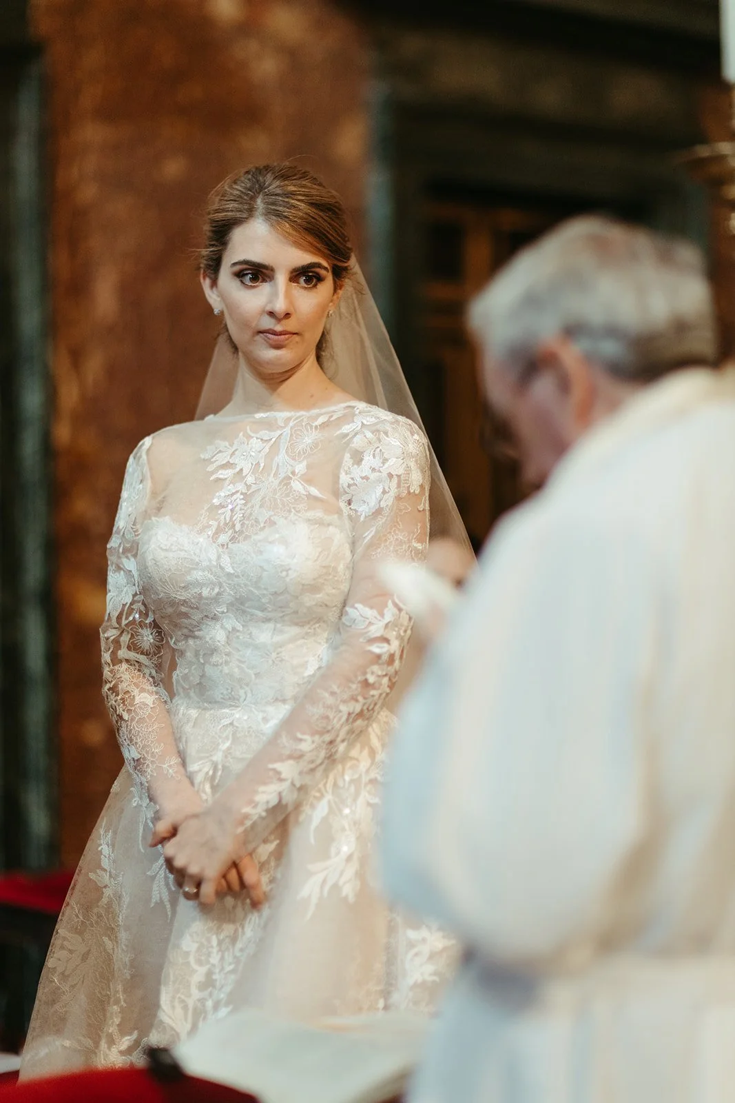 Corina escucha al sacerdote durante la ceremonia en la Basílica de San Lorenzo de El Escorial