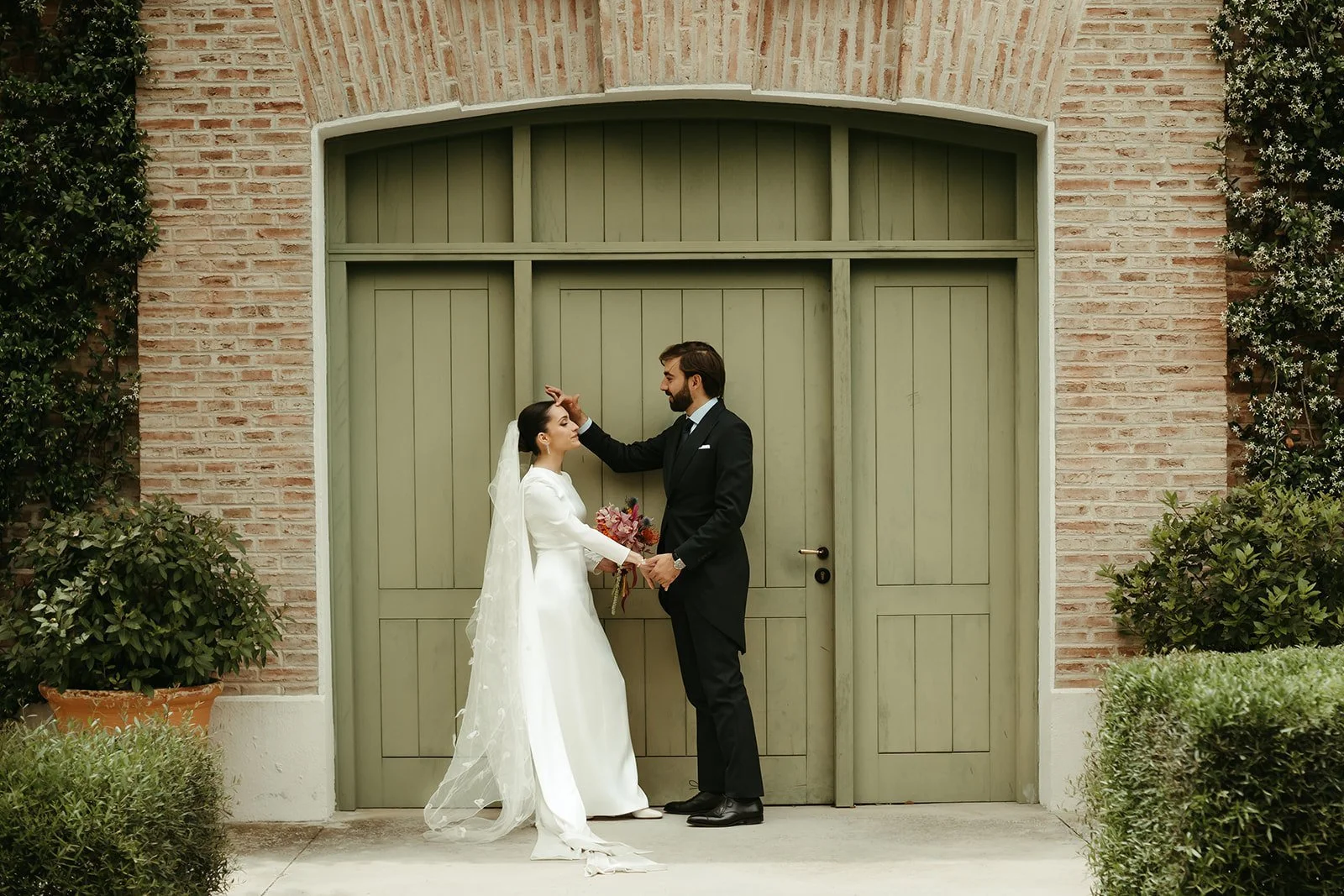 Emiliana y Emilio ante una gran puerta verde, foto elegida para su álbum