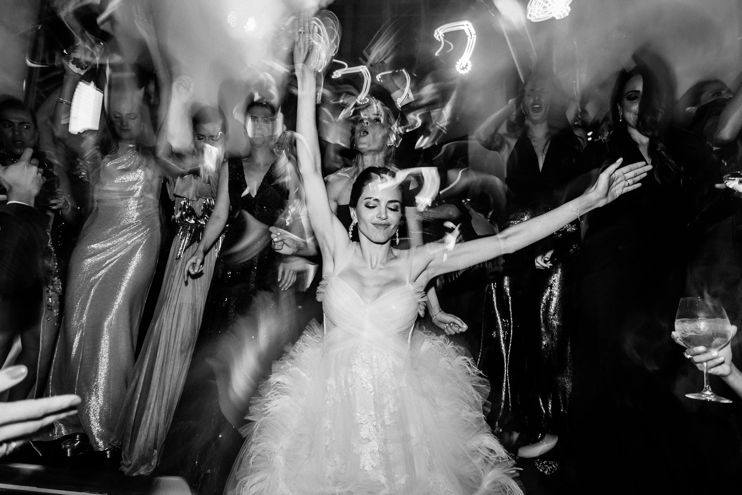 Mujer vestida de Novia bailando en una fiesta rodeada de varias personas