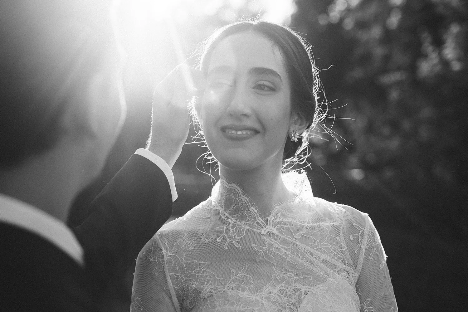 Black and white photo of the groom brushing back the bride’s hair in the afternoon sun, Madrid wedding