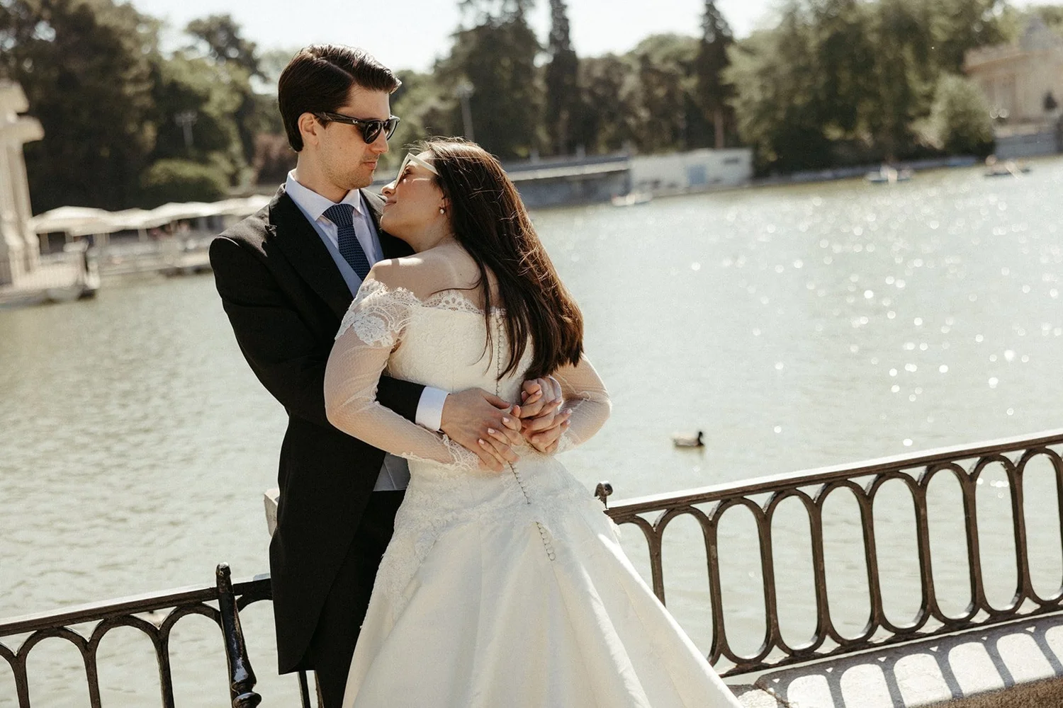 Bride and groom embracing by a lake during their post-wedding session