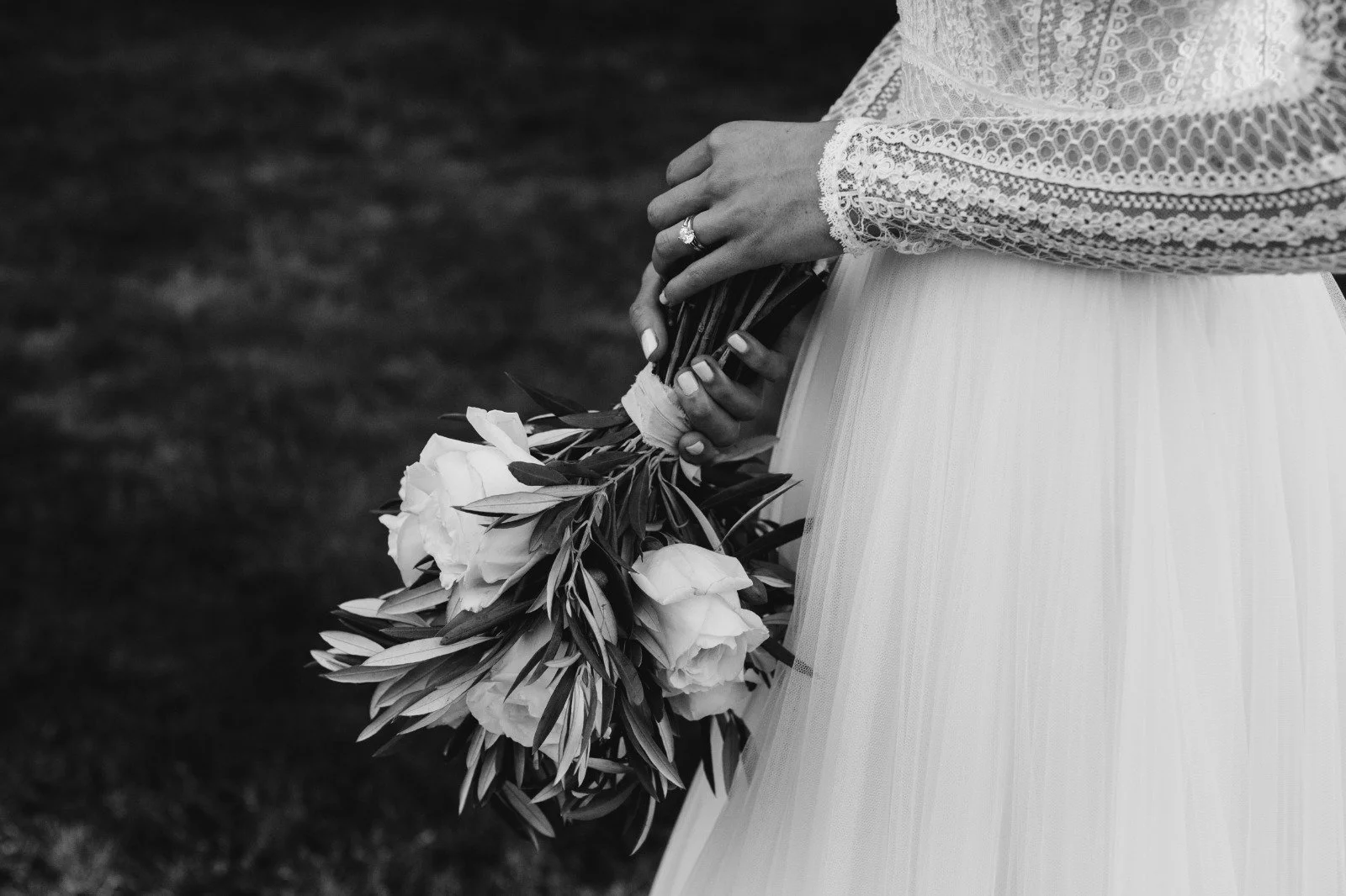 Mano de novia sosteniendo un ramo de flores en blanco y negro