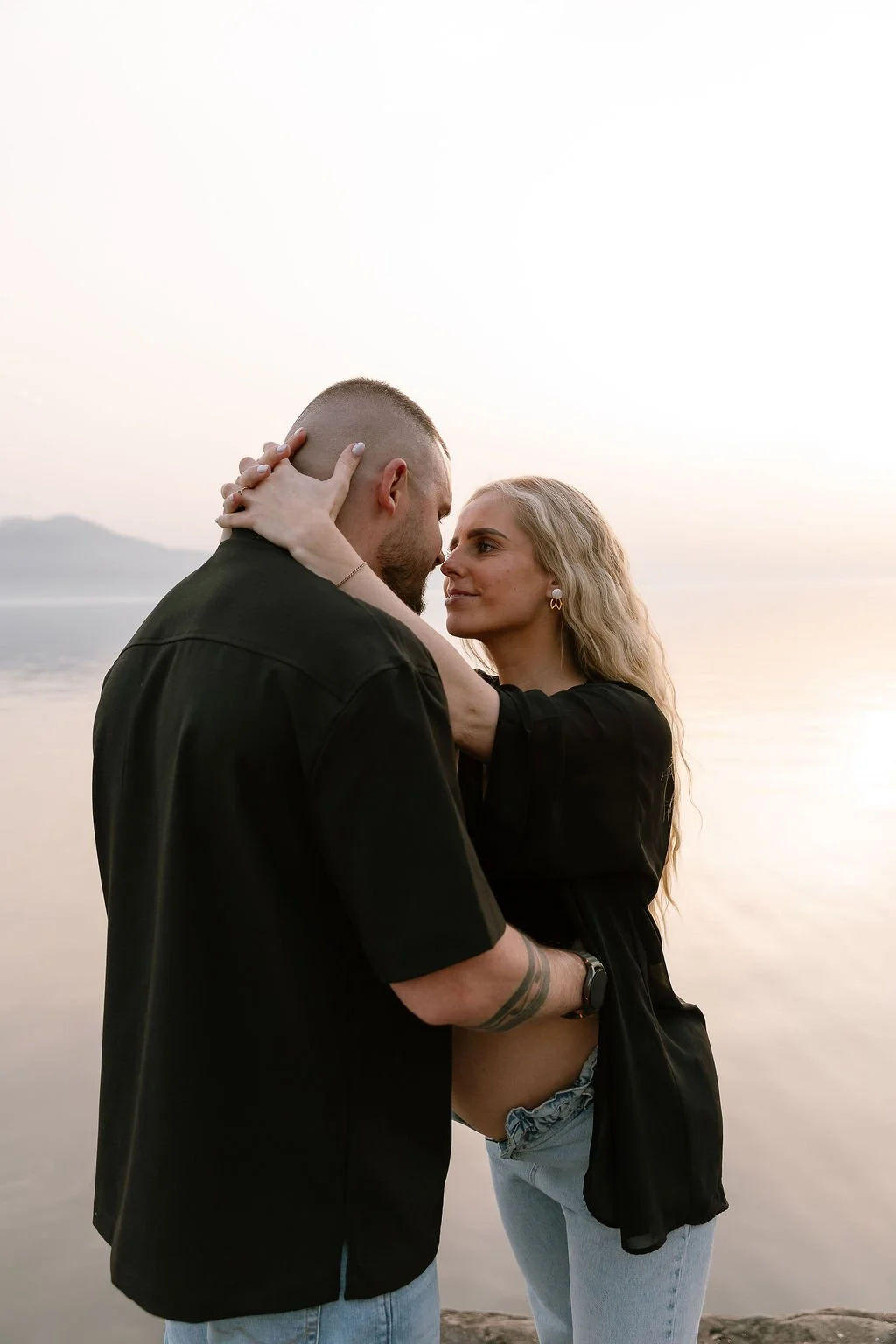 photo d'un couple s'enlaçant au bord de l'eau shooting grossesse