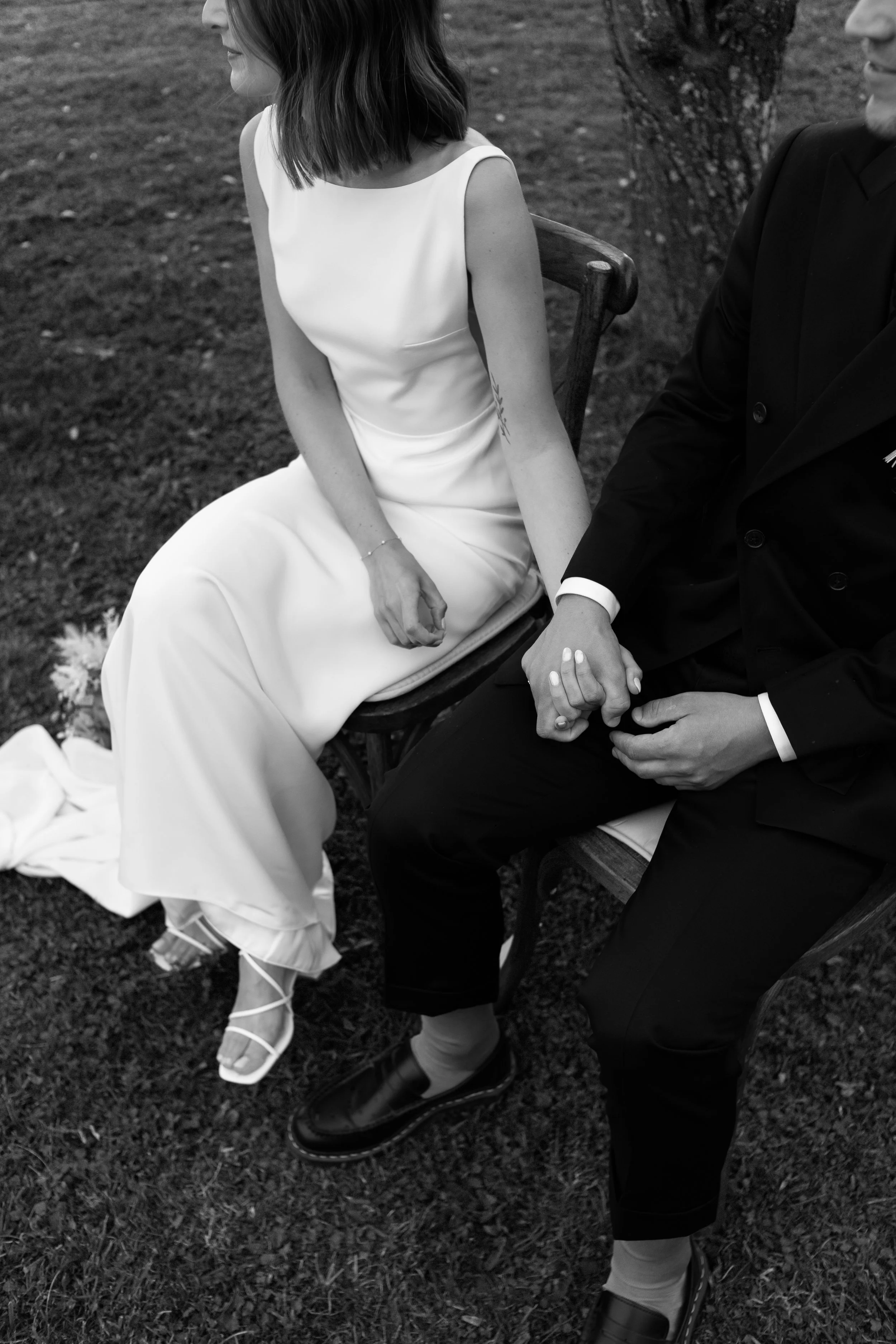 photo noir et blanc d'un couple se tenant la main pendant la cérémonie de mariage