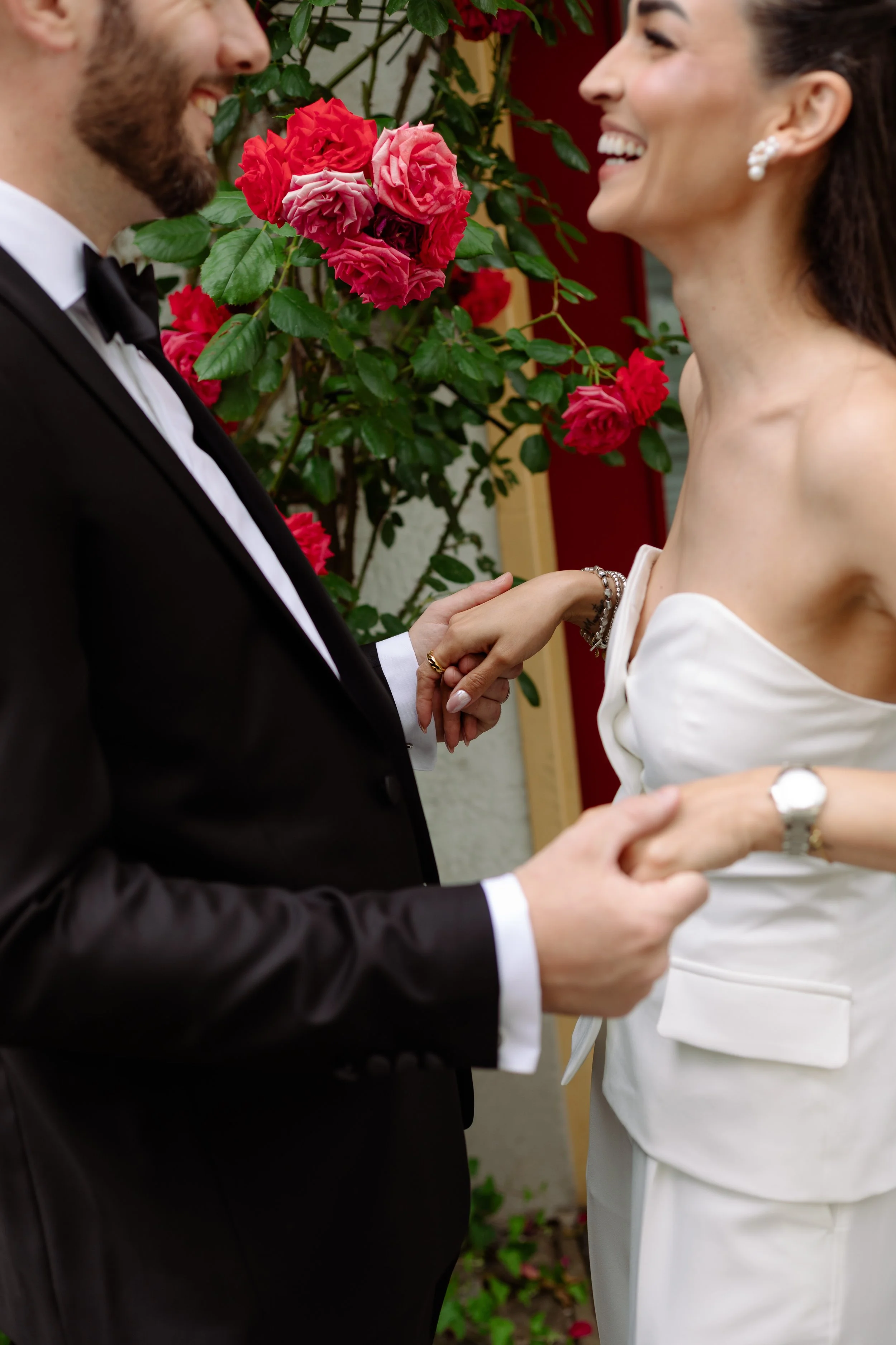 couple marié se tenant la main devant des roses Morat