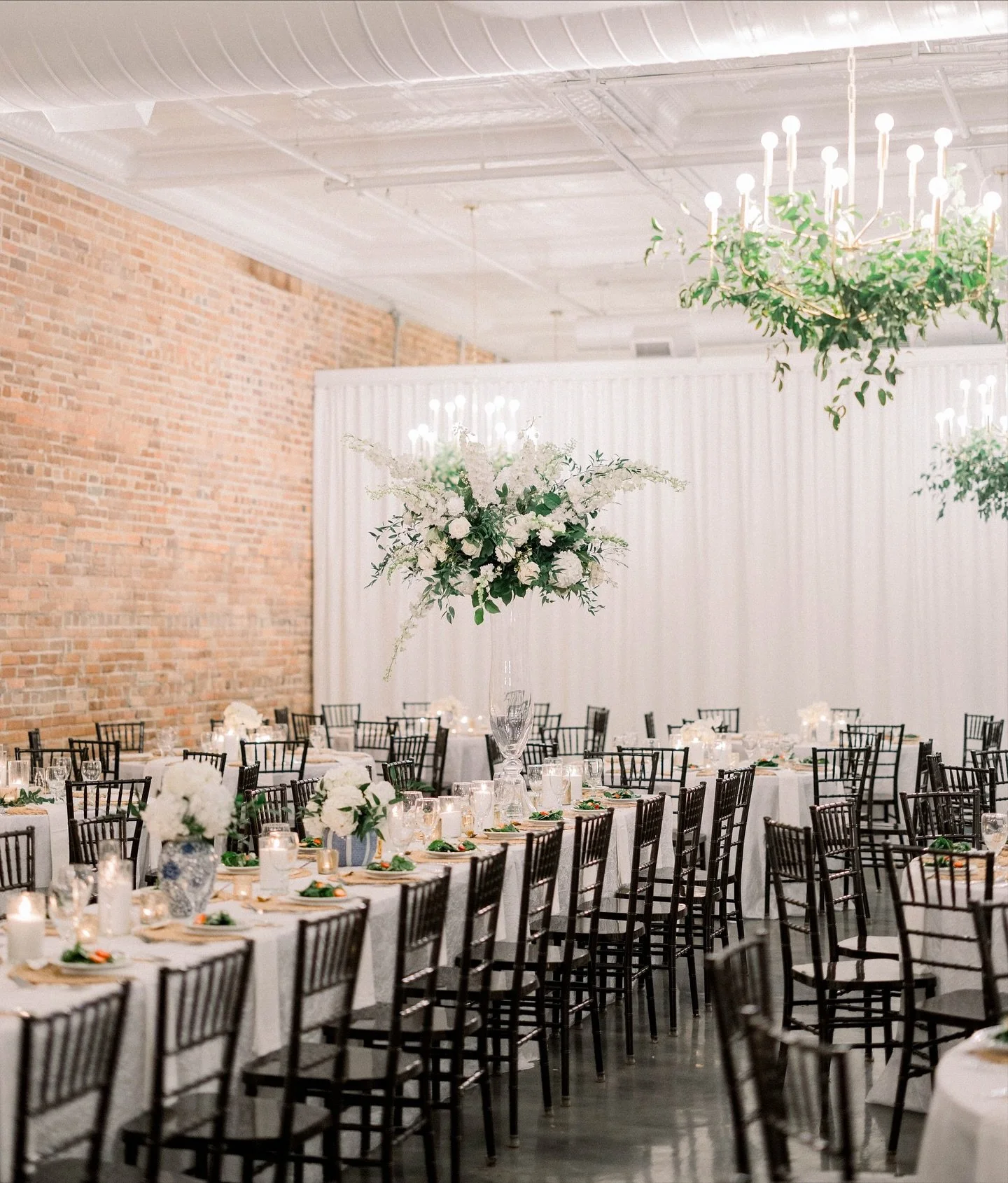 If you’re looking to create drama and dimension in a space, incorporating levels and variety is key—and one of the best ways to achieve this is through centerpieces. The contrast between the smaller blue-and-white vases and the tall, lush