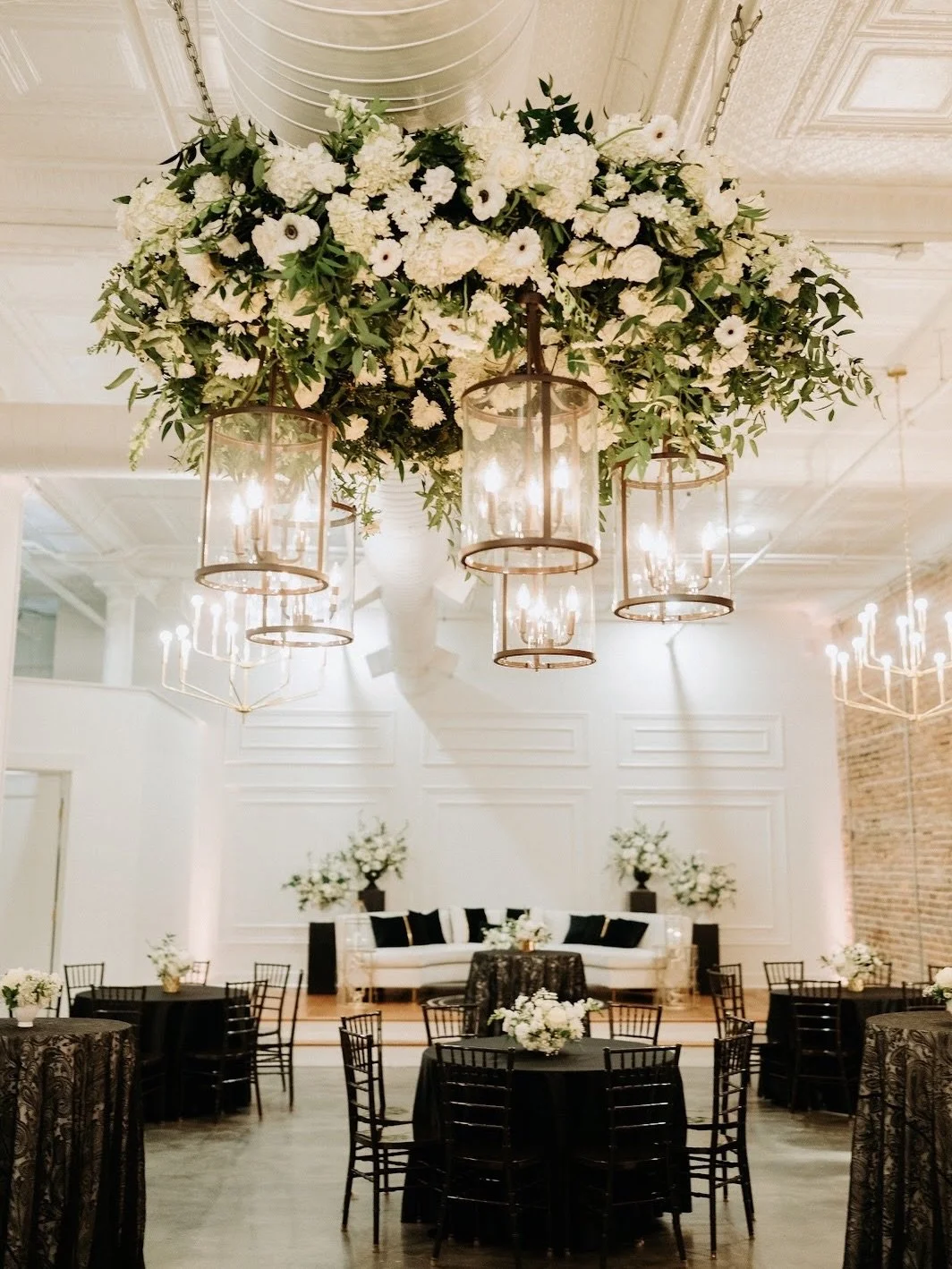 Two beautiful ways to elevate your venue space and make your reception feel even more intentional:

1. A ceiling floral installation over the dance floor creates a stunning focal point for your reception. It draws guests into the space, adds dimensio