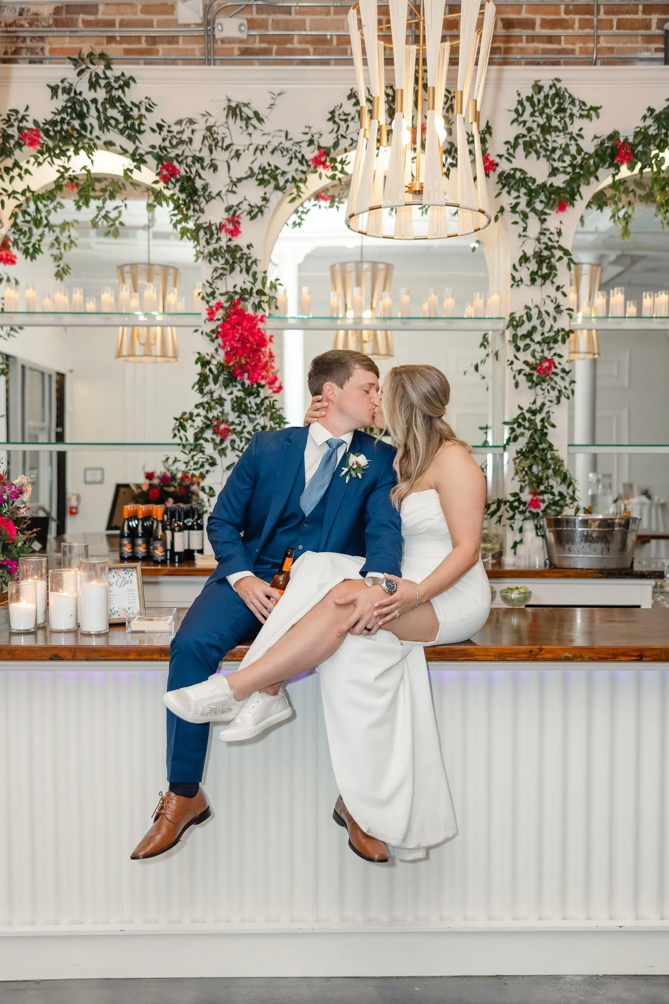 Newlyweds kiss while sitting on the bar at The Elia in NC