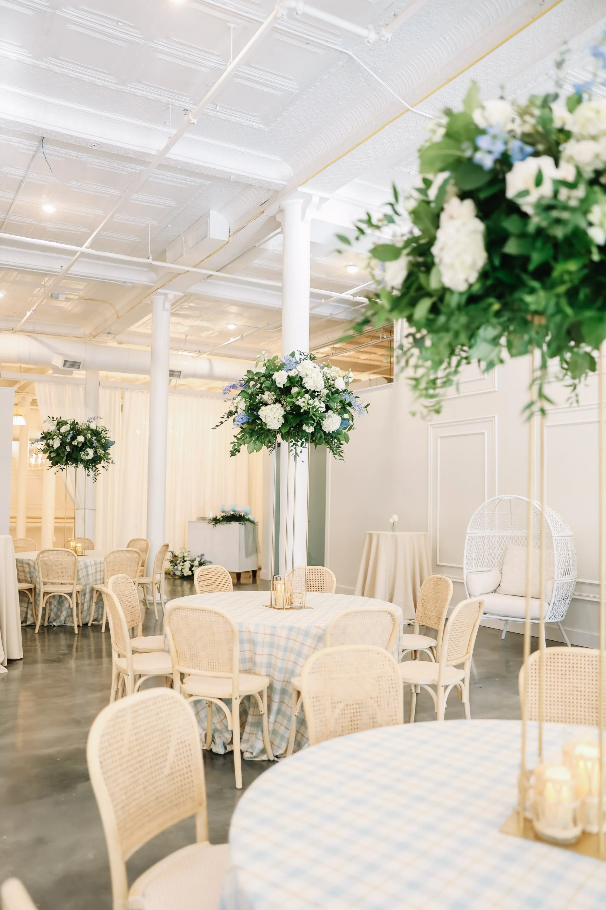 Wedding reception tables with tall floral centerpieces