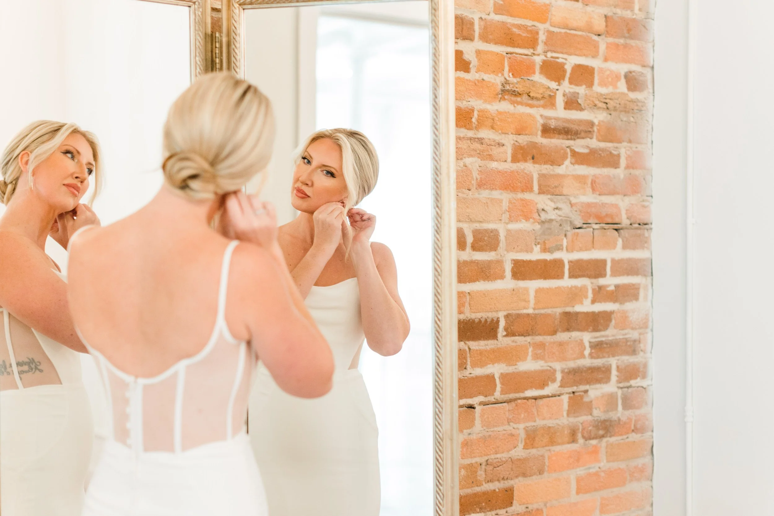 Bride putting on earrings in bridal suite at The Elia NC