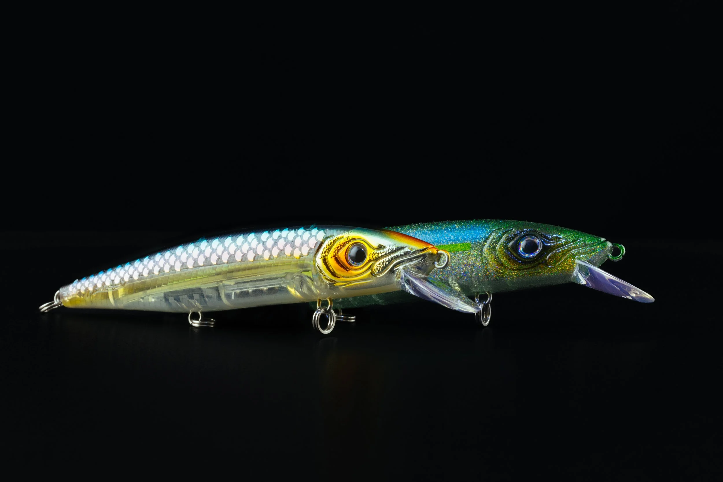 Two realistic fishing lures designed to look like fish, with detailed scales and vibrant colors, placed on a black background.