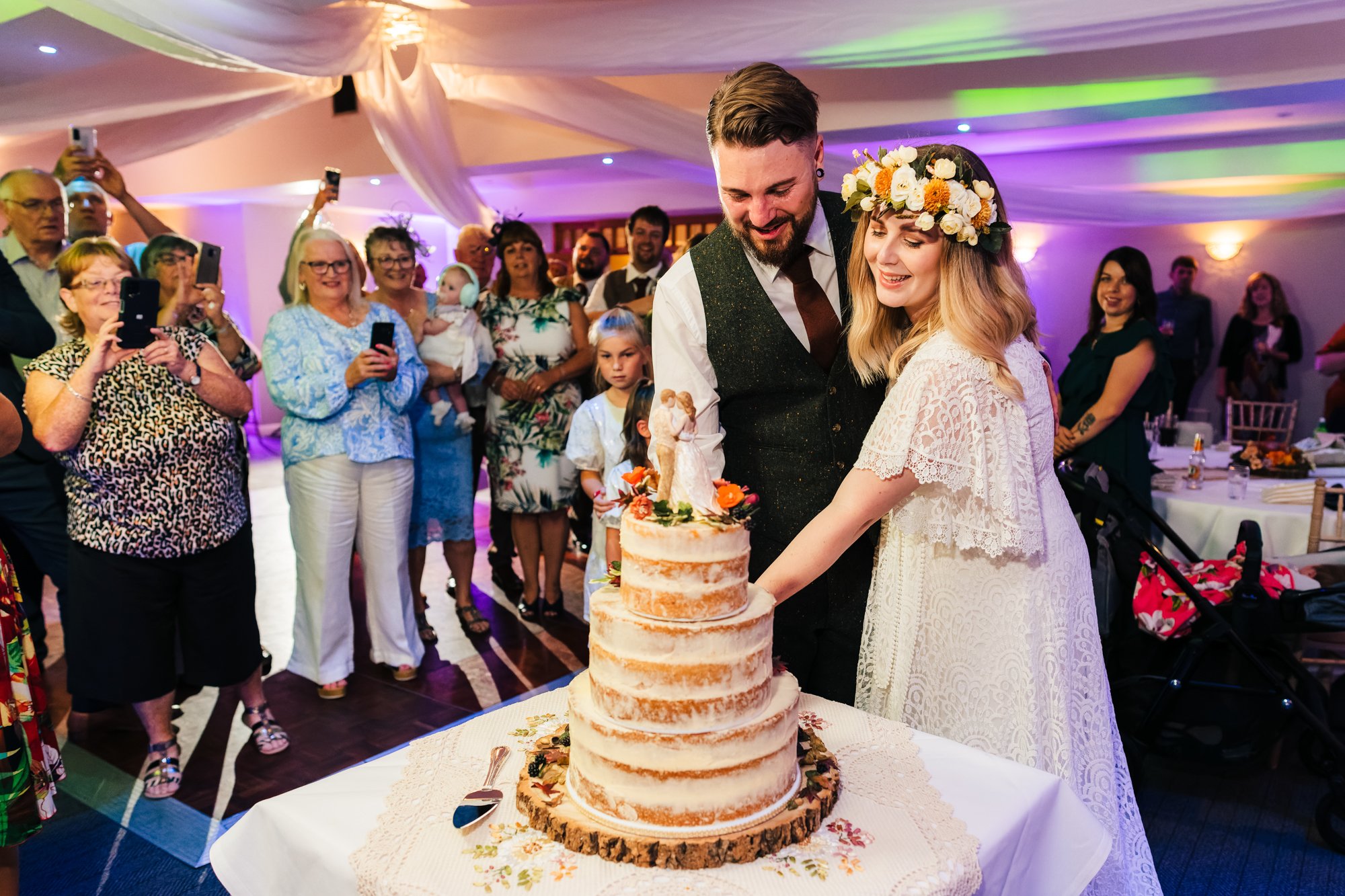 MAKENEY HALL WEDDING PHOTOGRAPHY - bride and groom cutting the wedding cake at Makeney Hall
