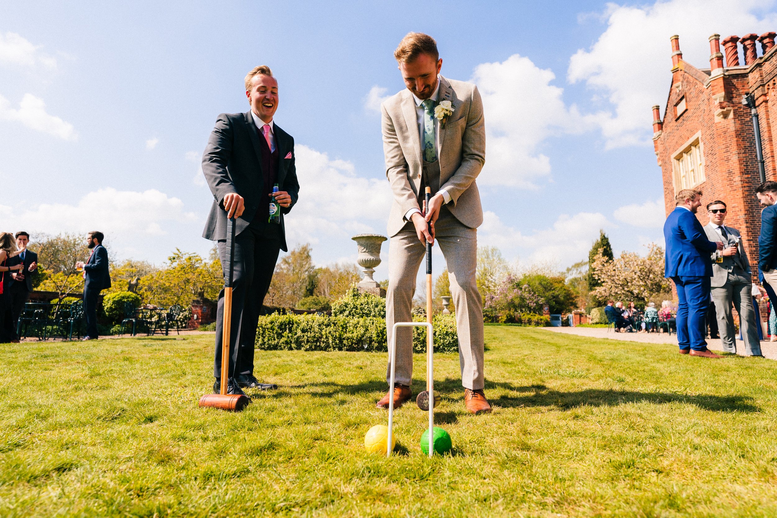 HODSOCK PRIORY WEDDING PHOTOGRAPHY - groom plays croquet in the gardens of hodsock priory