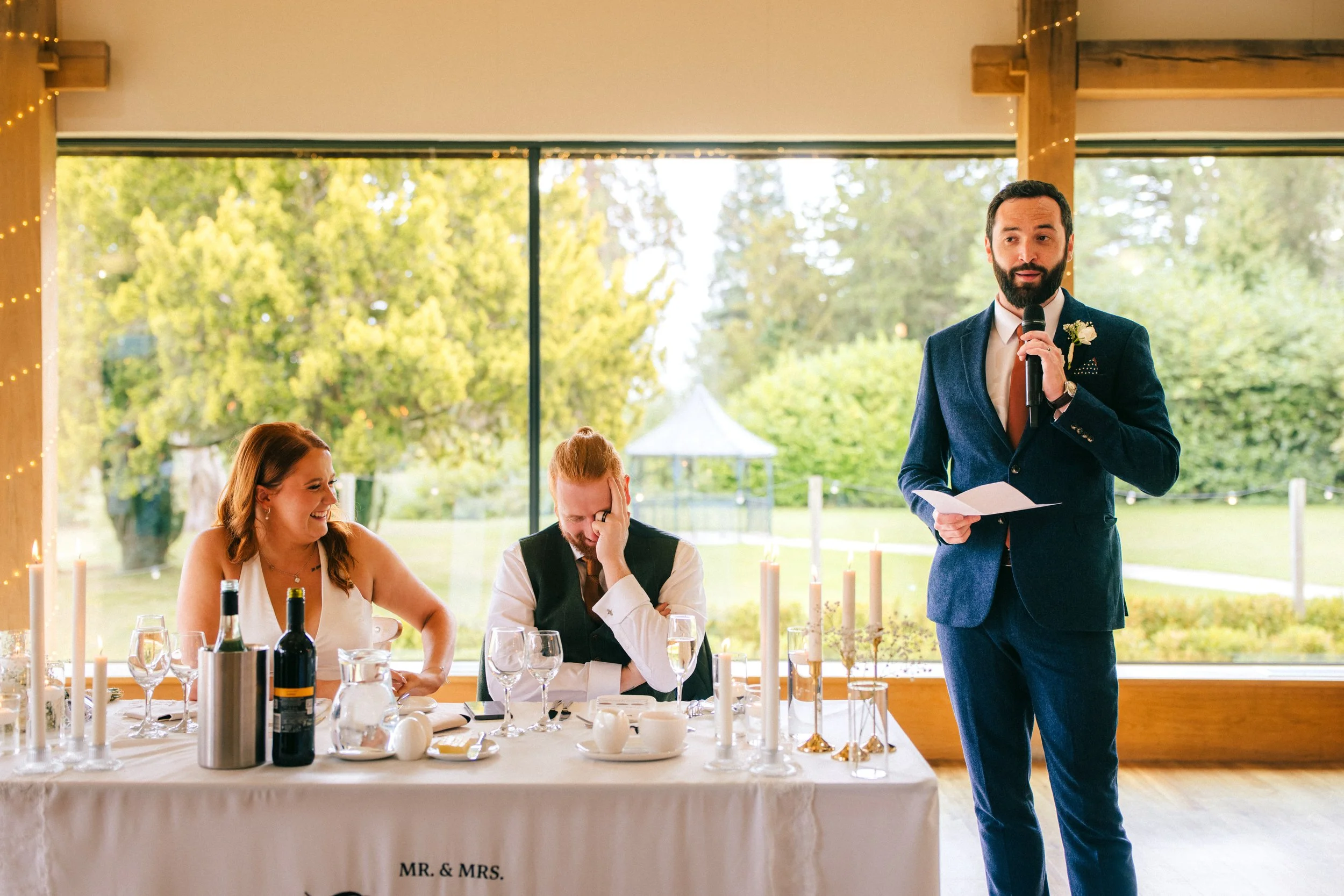 BREDENBURY COURT BARNS WEDDING PHOTOGRAPHER - groom reacting to the best mans speech during the wedding at Bredenbury Court Barns