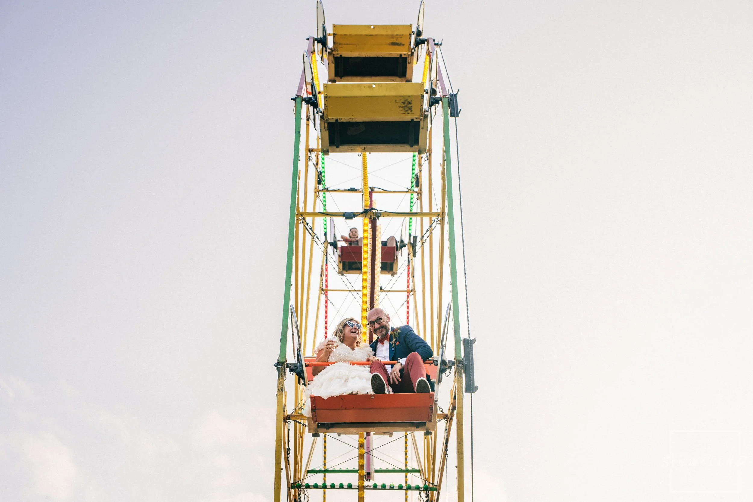 Festival Wedding Wedding Photographer | Bride and Groom enjoying a ride on a ferris wheel on their wedding day