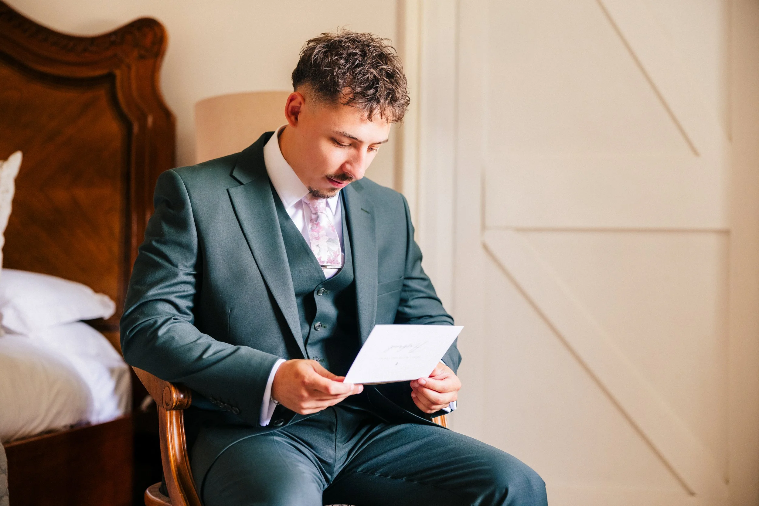 SWANCAR FARM WEDDING PHOTOGRAPHY - groom reading a letter which the bride has written to him for their wedding
