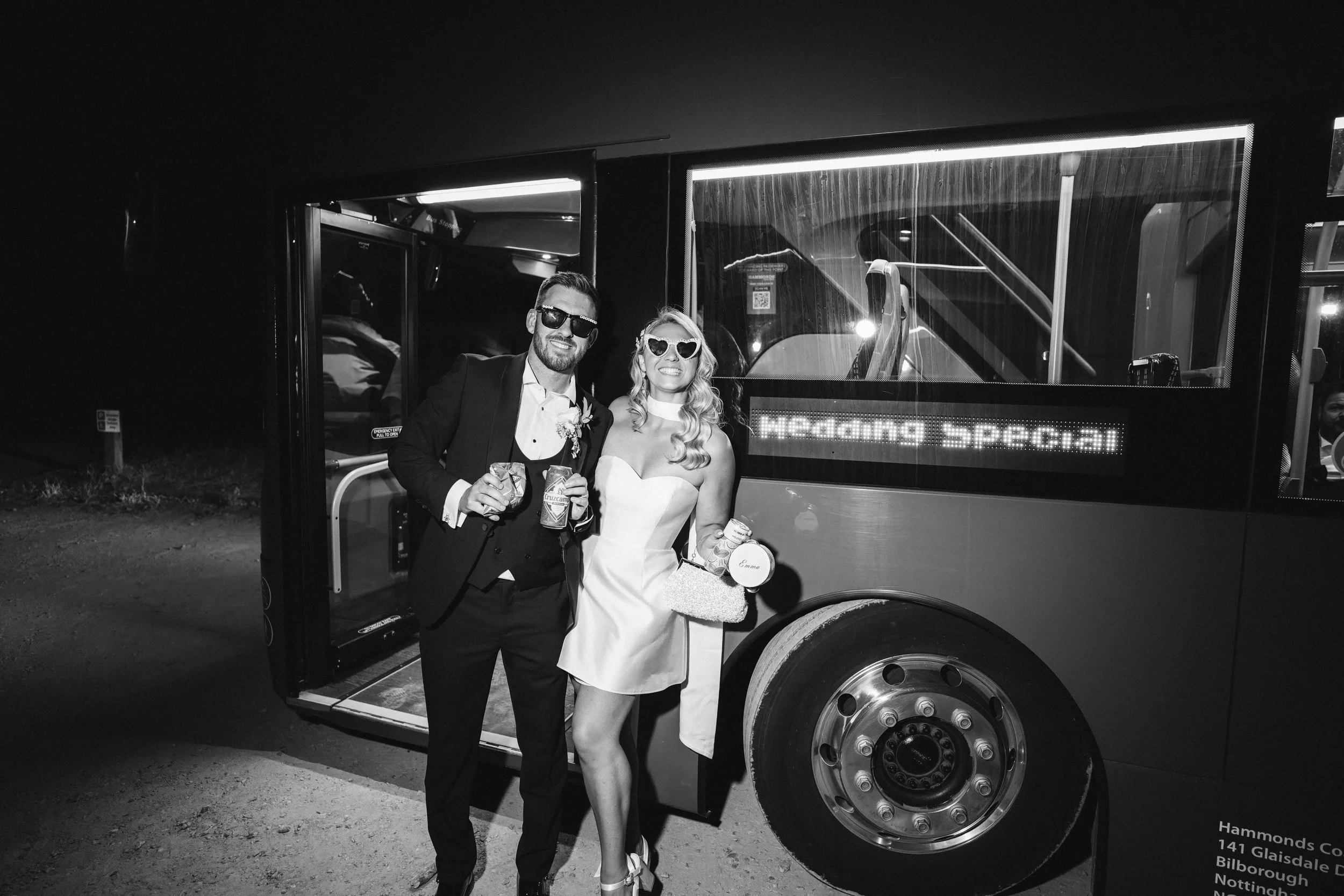 Bride and groom standing infront of a bus ready to continue the wedding party at a nightclub in Nottingham city centre