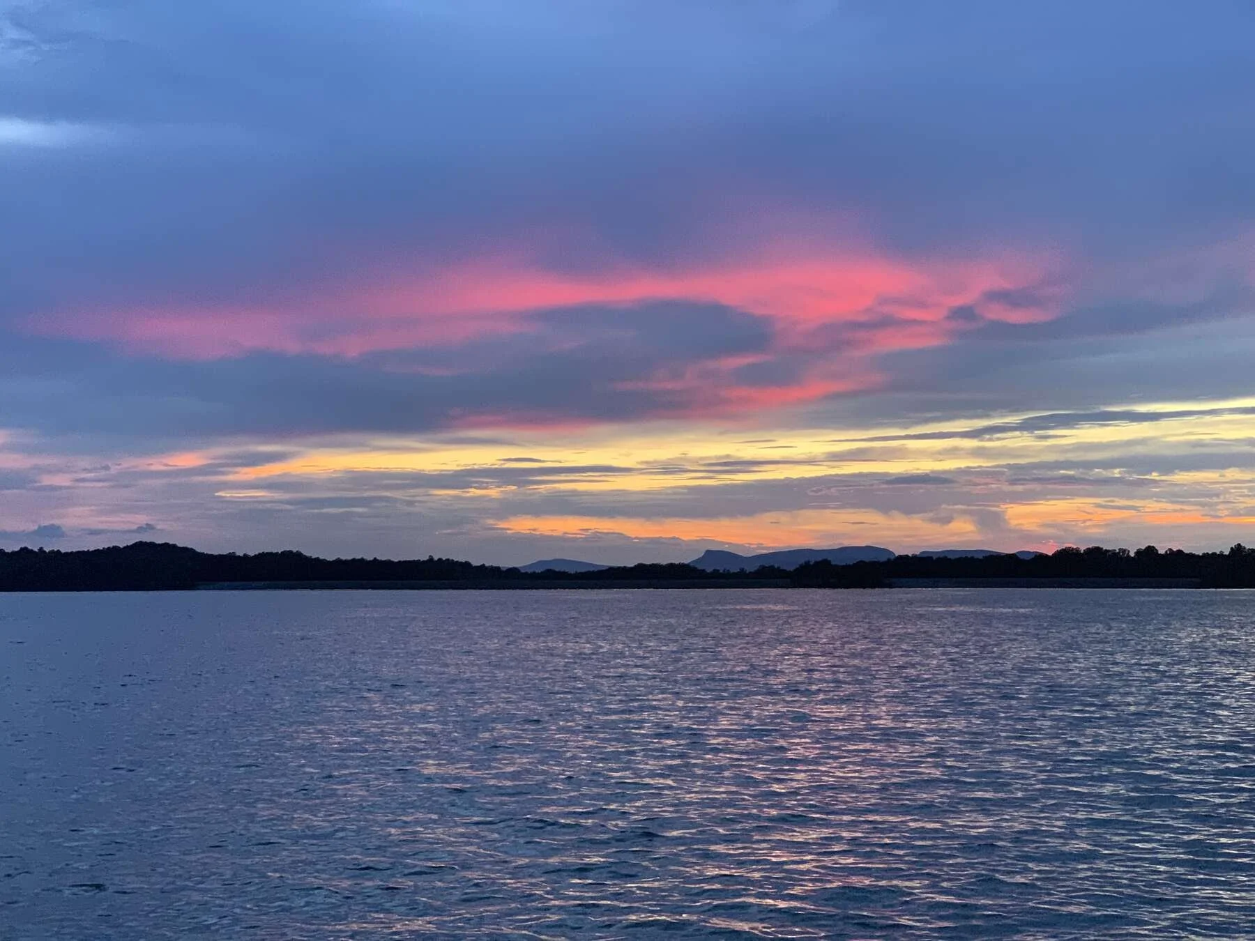 Belews Lake NC shoreline at sunset with calm water and tree reflections