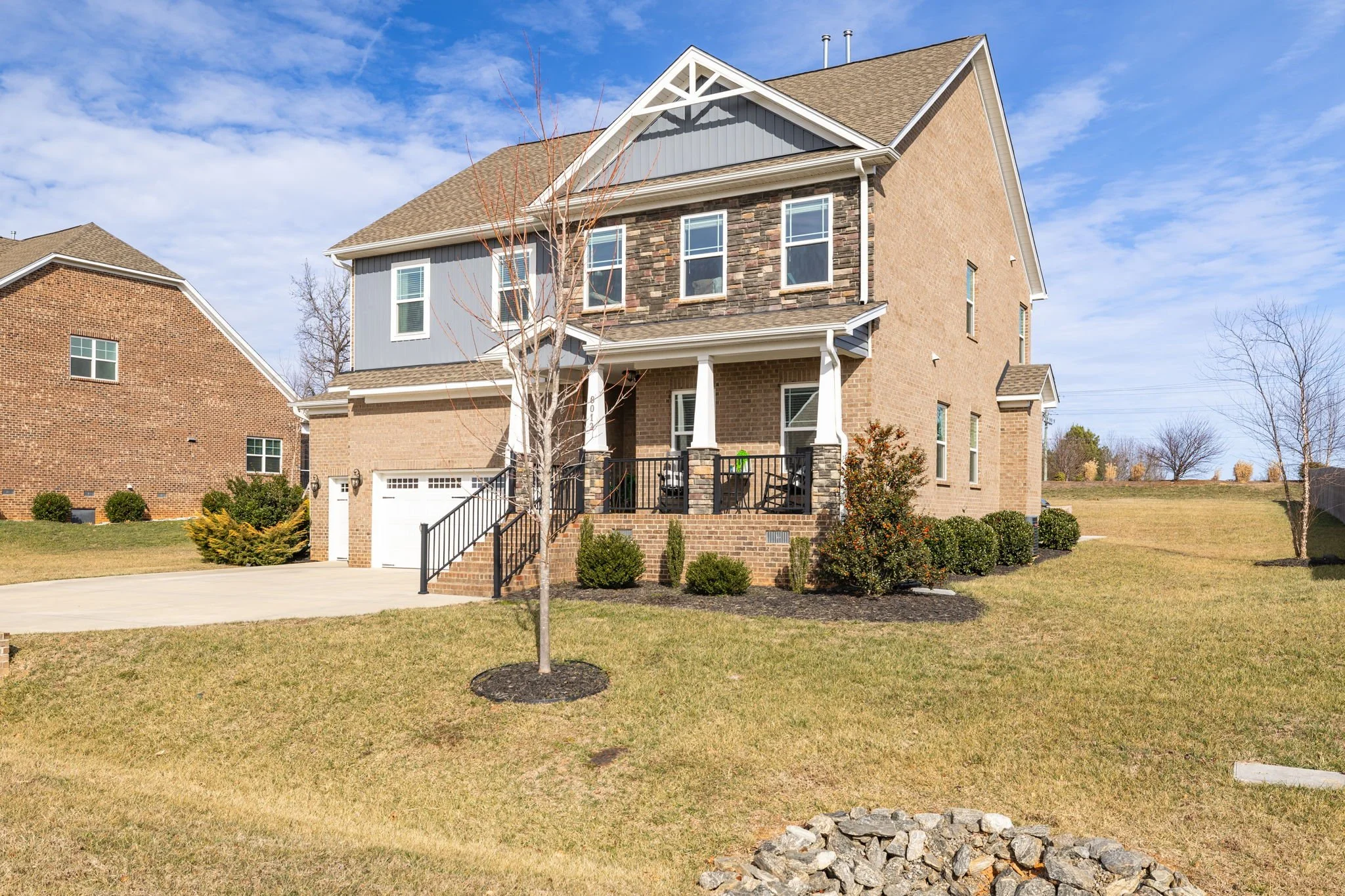 Stone accent exterior and covered porch at 8012 NW Meadows Drive, Stokesdale, NC 27357. Listed by Delia Knight, REALTOR® with Howard Hanna Allen Tate Real Estate.