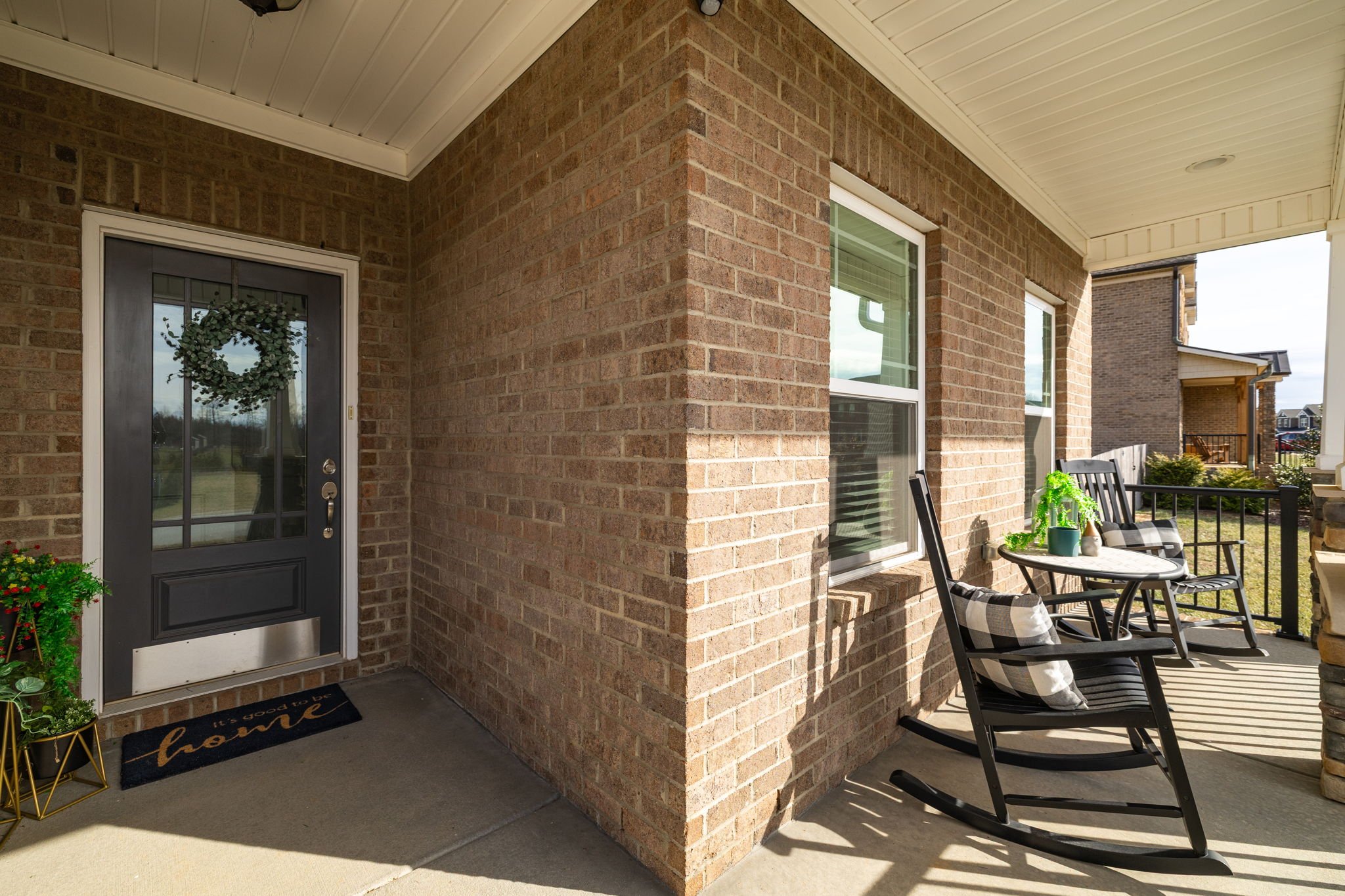 Covered front porch with rocking chairs at 8012 NW Meadows Drive, Stokesdale, NC 27357. Listed by Delia Knight, REALTOR® with Howard Hanna Allen Tate Real Estate.