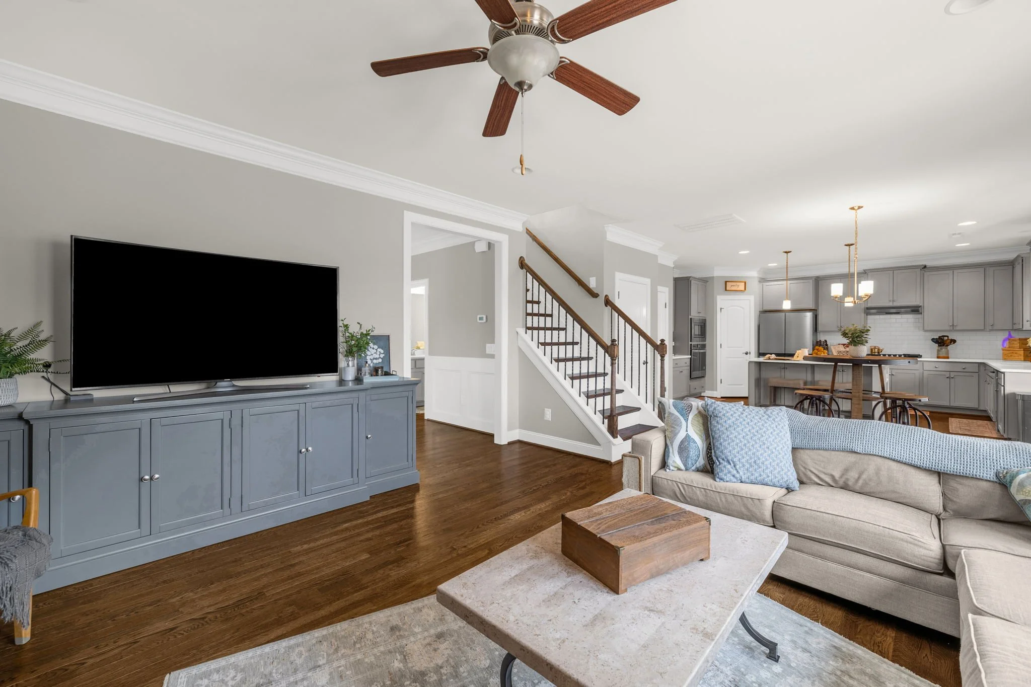 Living room with media wall and open staircase at 8012 NW Meadows Drive, Stokesdale, NC 27357. Listed by Delia Knight, REALTOR® with Howard Hanna Allen Tate Real Estate.