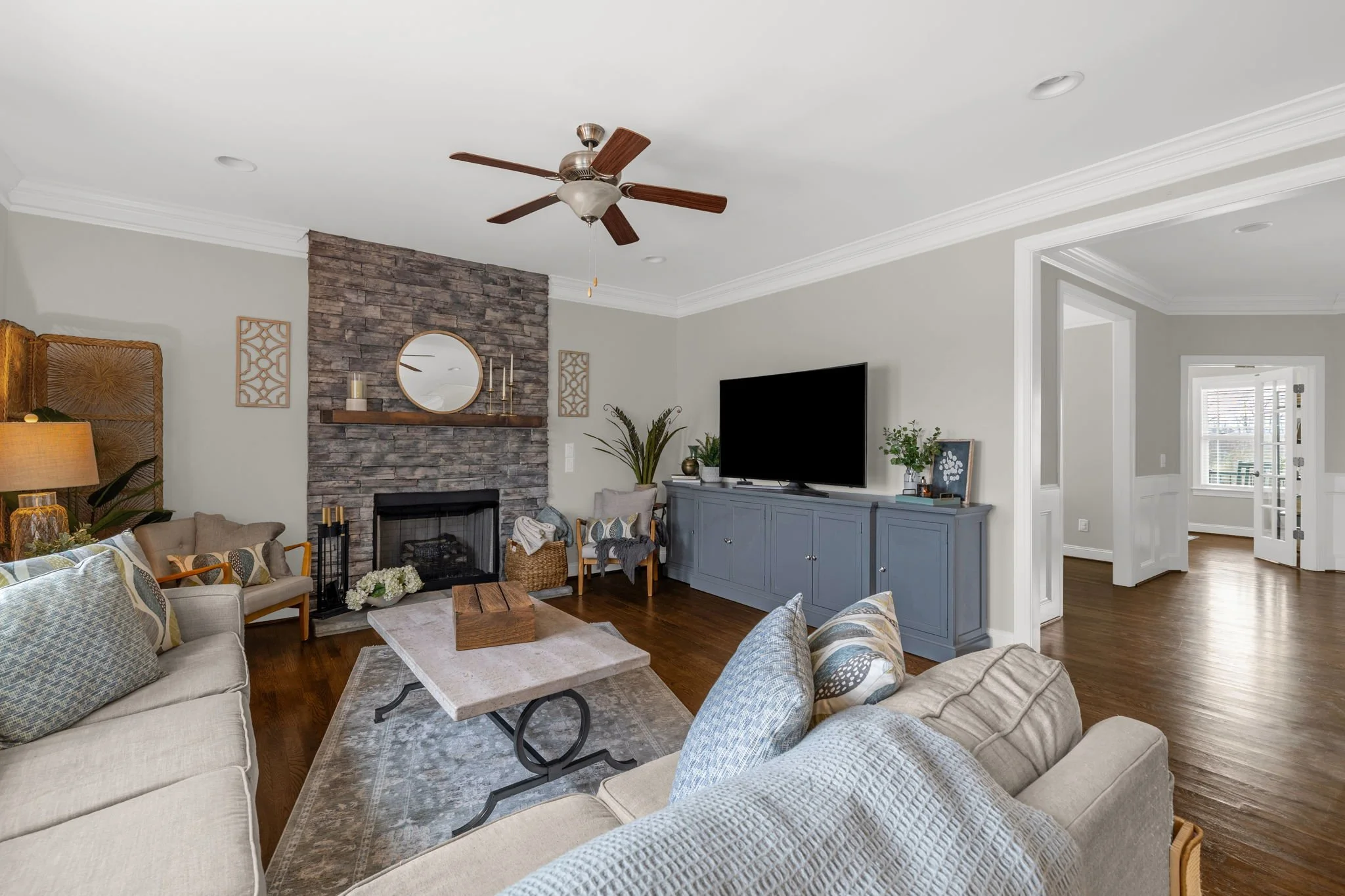 Living room with stone fireplace and media wall at 8012 NW Meadows Drive, Stokesdale, NC 27357. Listed by Delia Knight, REALTOR® with Howard Hanna Allen Tate Real Estate.