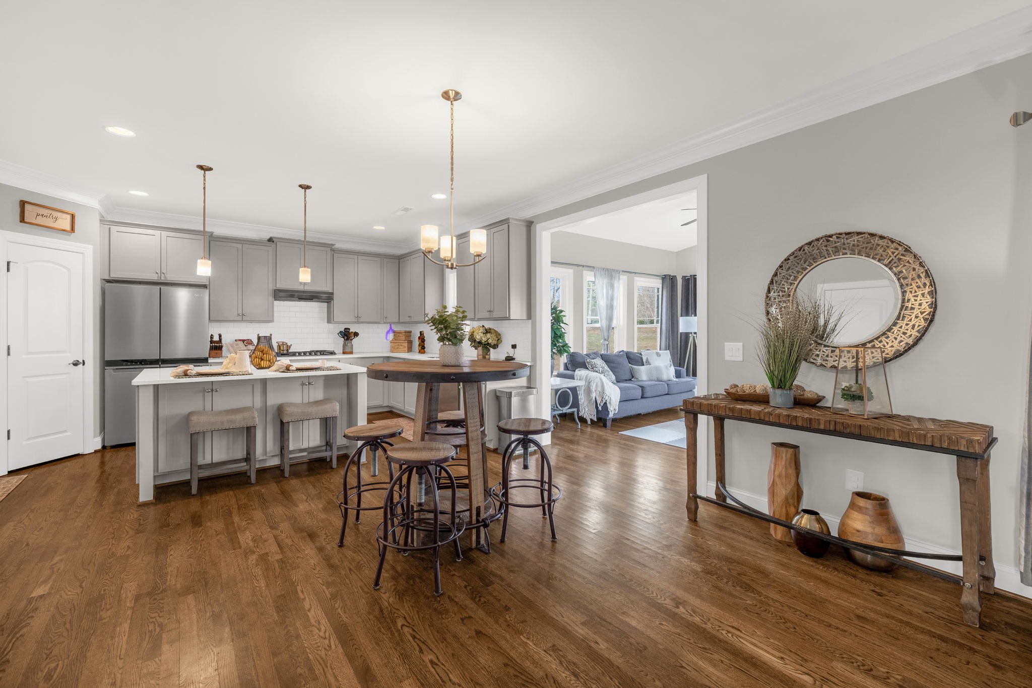 Kitchen with gray cabinets, island, and pendant lights at 8012 NW Meadows Drive, Stokesdale, NC 27357. Listed by Delia Knight, REALTOR® with Howard Hanna Allen Tate Real Estate.