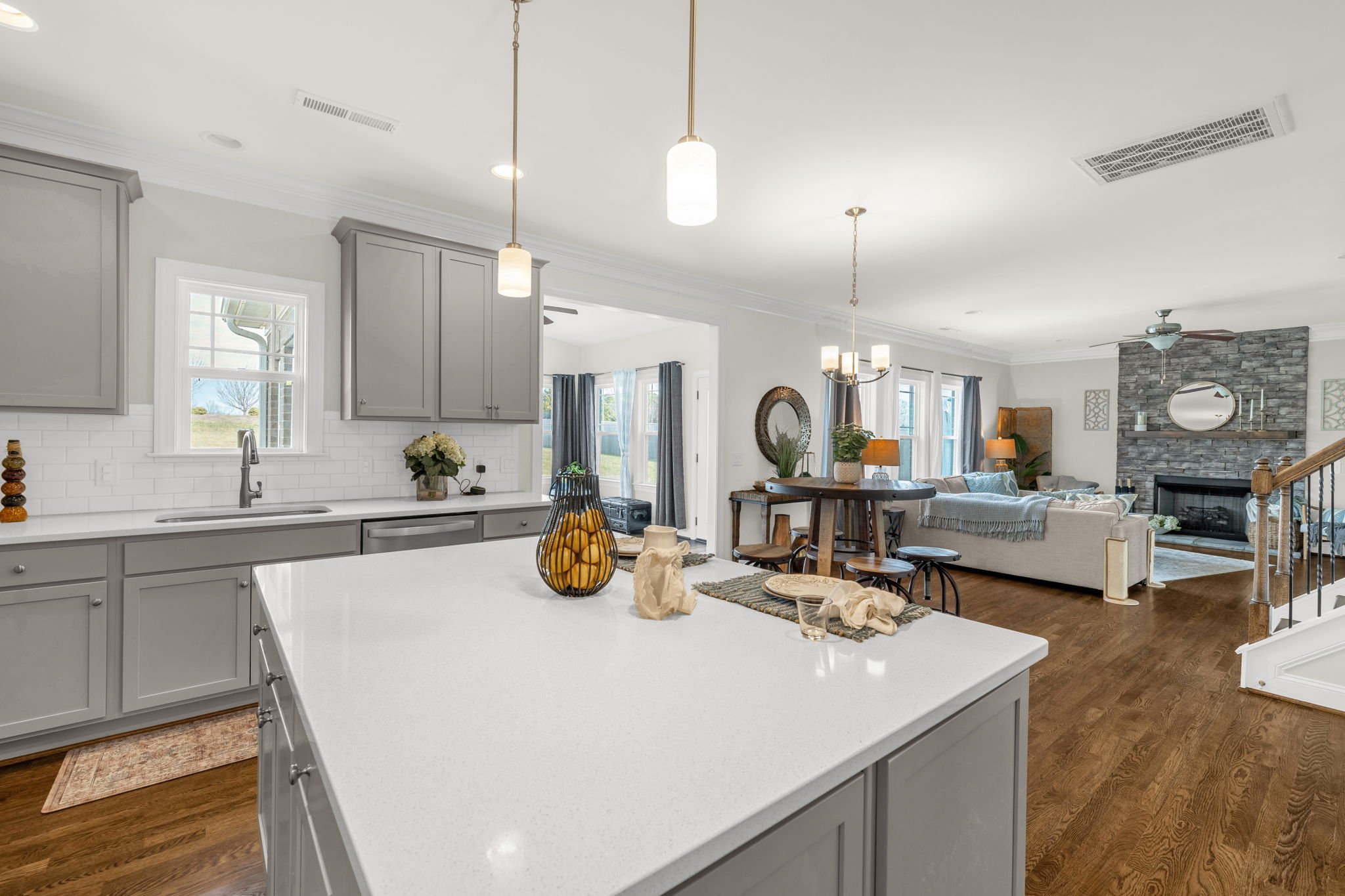 Kitchen island with view to the living room fireplace at 8012 NW Meadows Drive, Stokesdale, NC 27357. Listed by Delia Knight, REALTOR® with Howard Hanna Allen Tate Real Estate.
