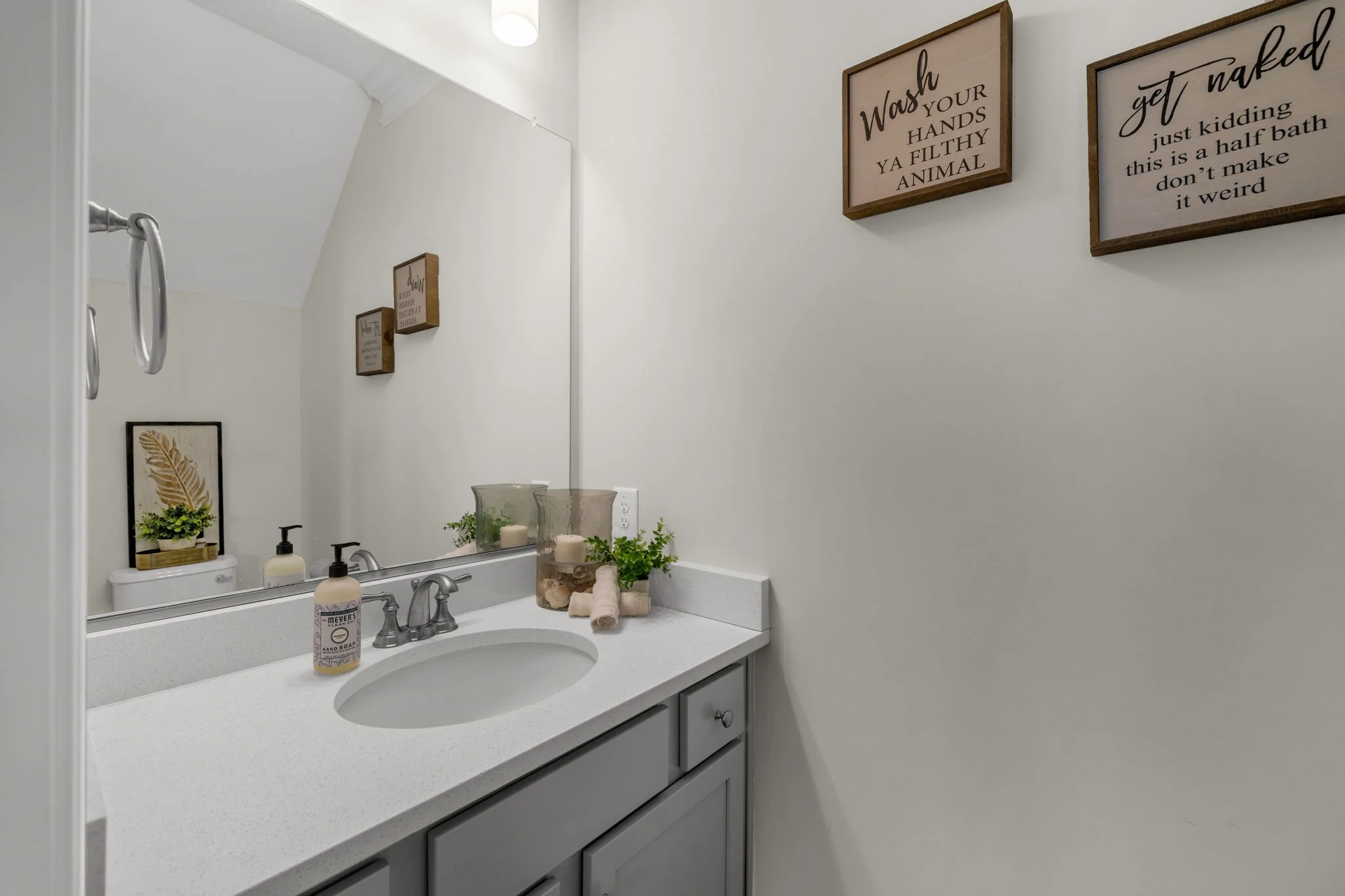 First-floor half bath with gray vanity at 8012 NW Meadows Drive, Stokesdale, NC 27357. Listed by Delia Knight, REALTOR® with Howard Hanna Allen Tate Real Estate.