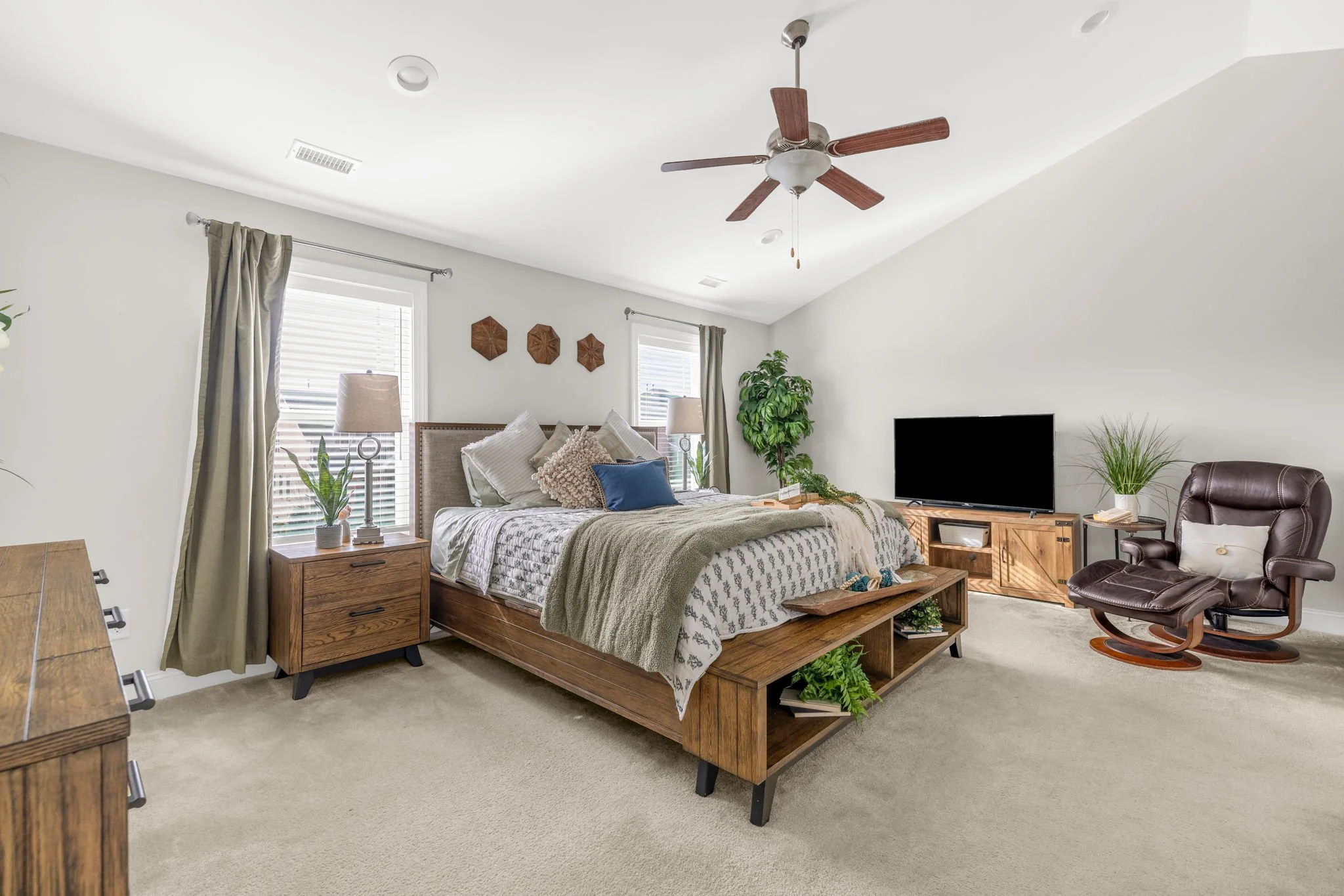 Primary bedroom with vaulted ceiling and ceiling fan at 8012 NW Meadows Drive, Stokesdale, NC 27357. Listed by Delia Knight, REALTOR® with Howard Hanna Allen Tate Real Estate.