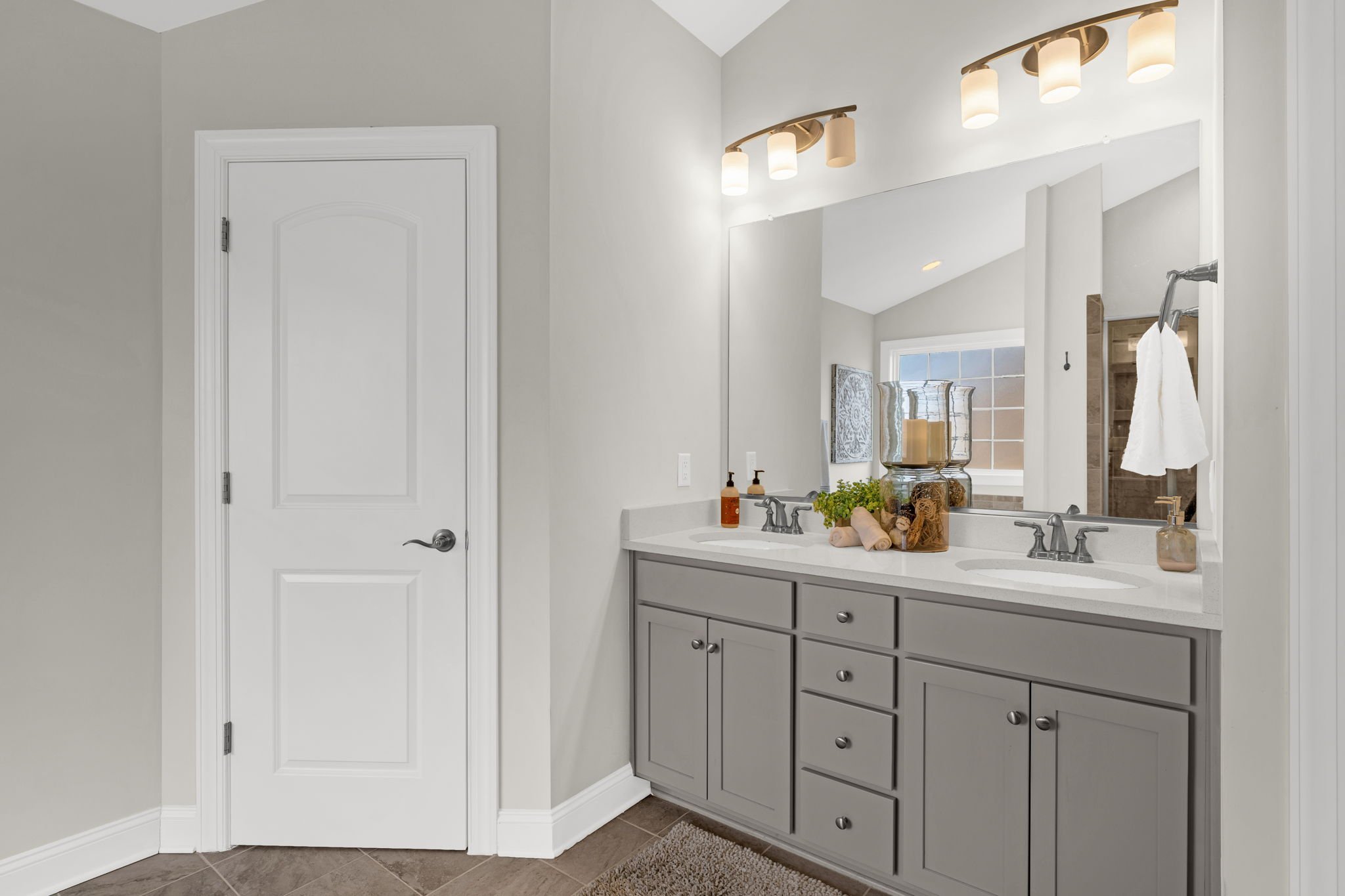 Primary bathroom with gray double vanity and quartz top at 8012 NW Meadows Drive, Stokesdale, NC 27357. Listed by Delia Knight, REALTOR® with Howard Hanna Allen Tate Real Estate.