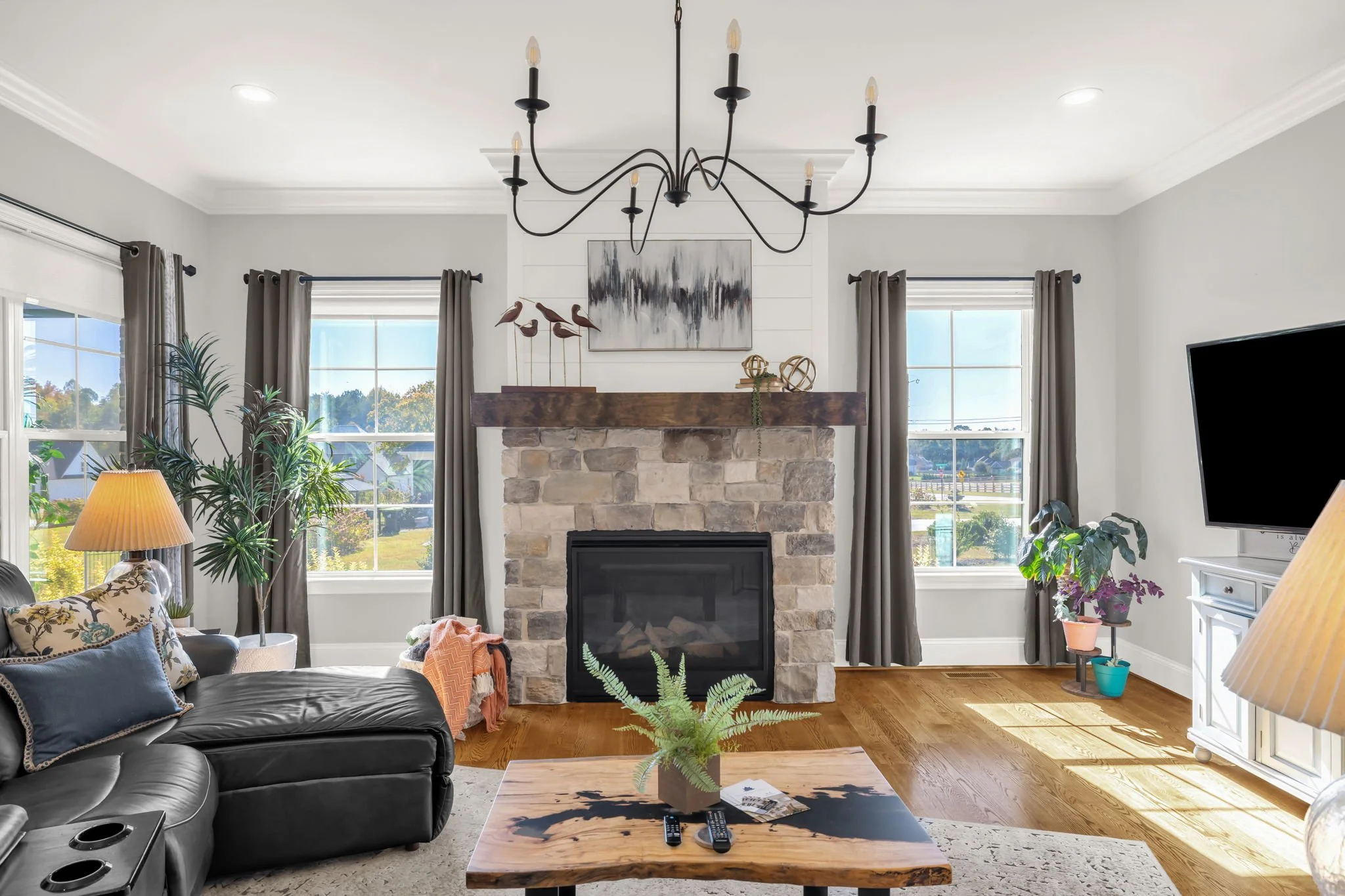 Bright living room with stone fireplace showing professional listing photography – Oak Ridge, NC 27310 | real estate photo staging example