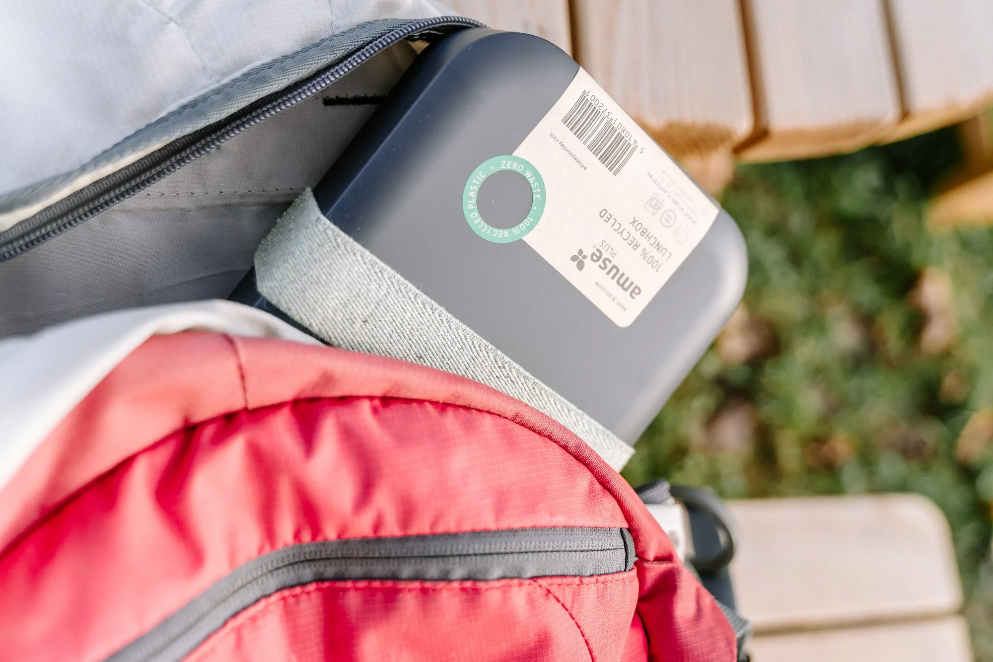 Een rugzak met een siliconen voedselcontainer in een buitenomgeving.