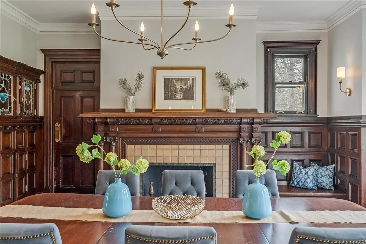 Formal dining room with fireplace and wood paneling in South Orange home  Caption: