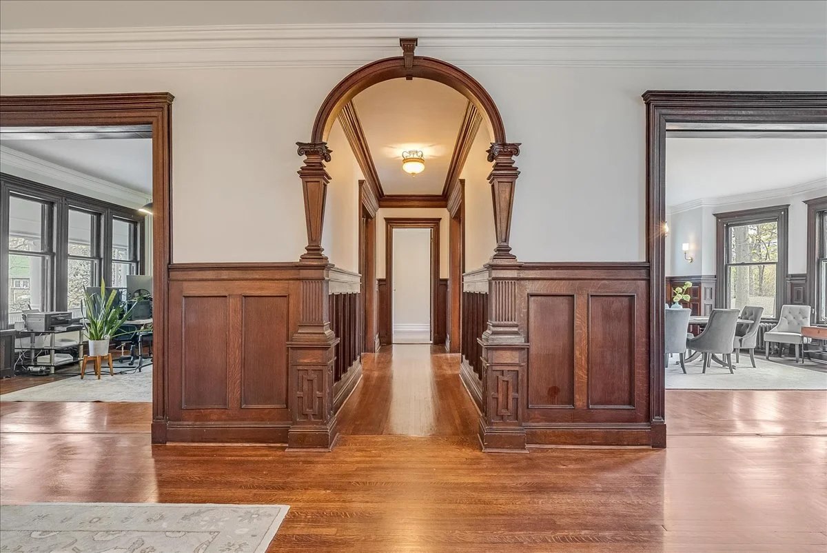 Arched hallway with detailed wood paneling in South Orange home