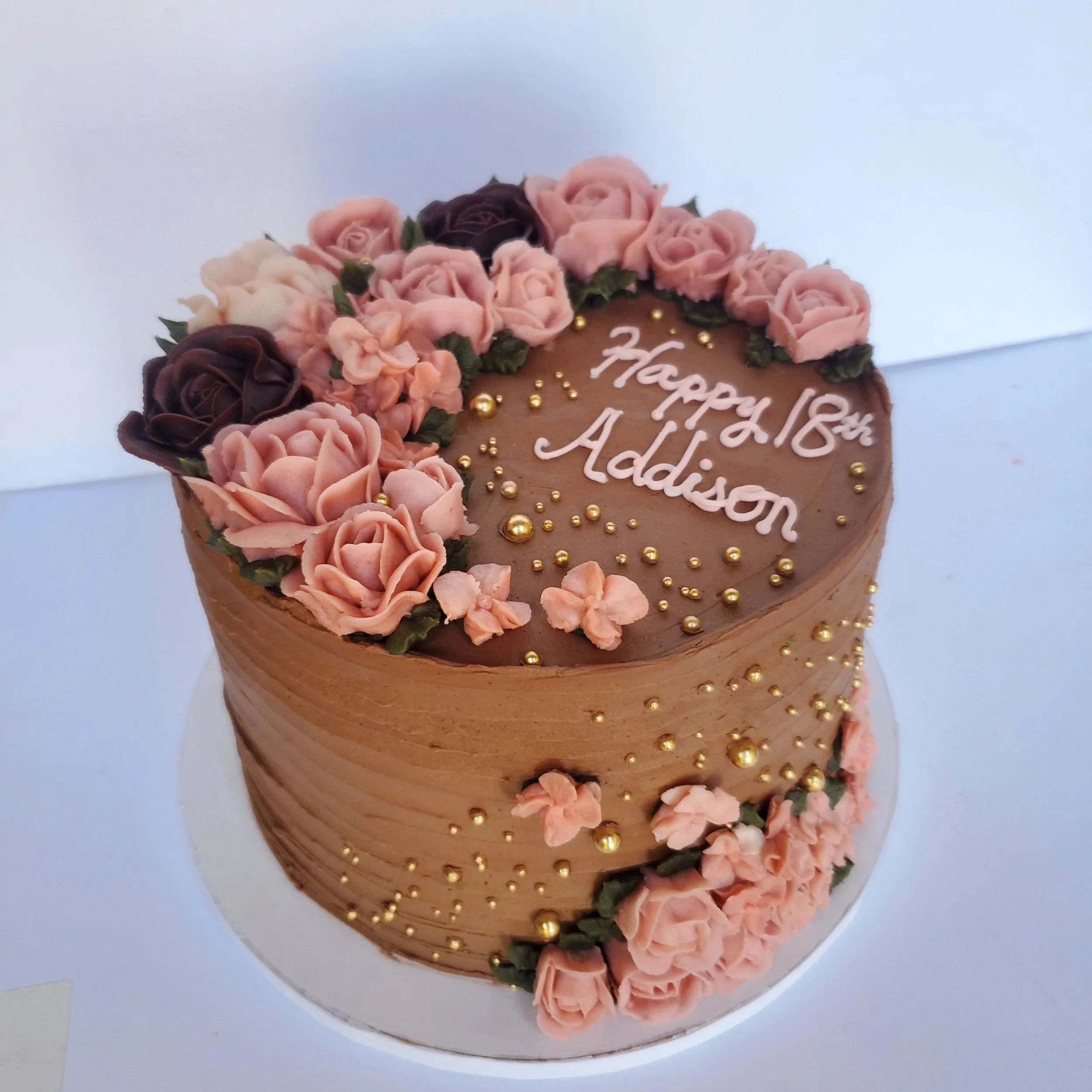 chocolate buttercream cake with pink buttercream flowers