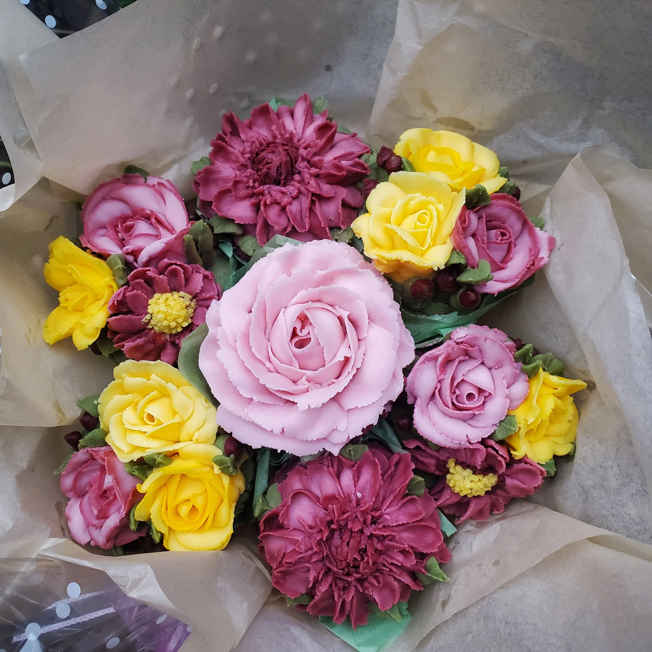 light pink, maroon, and yellow buttercream floral cupcakes