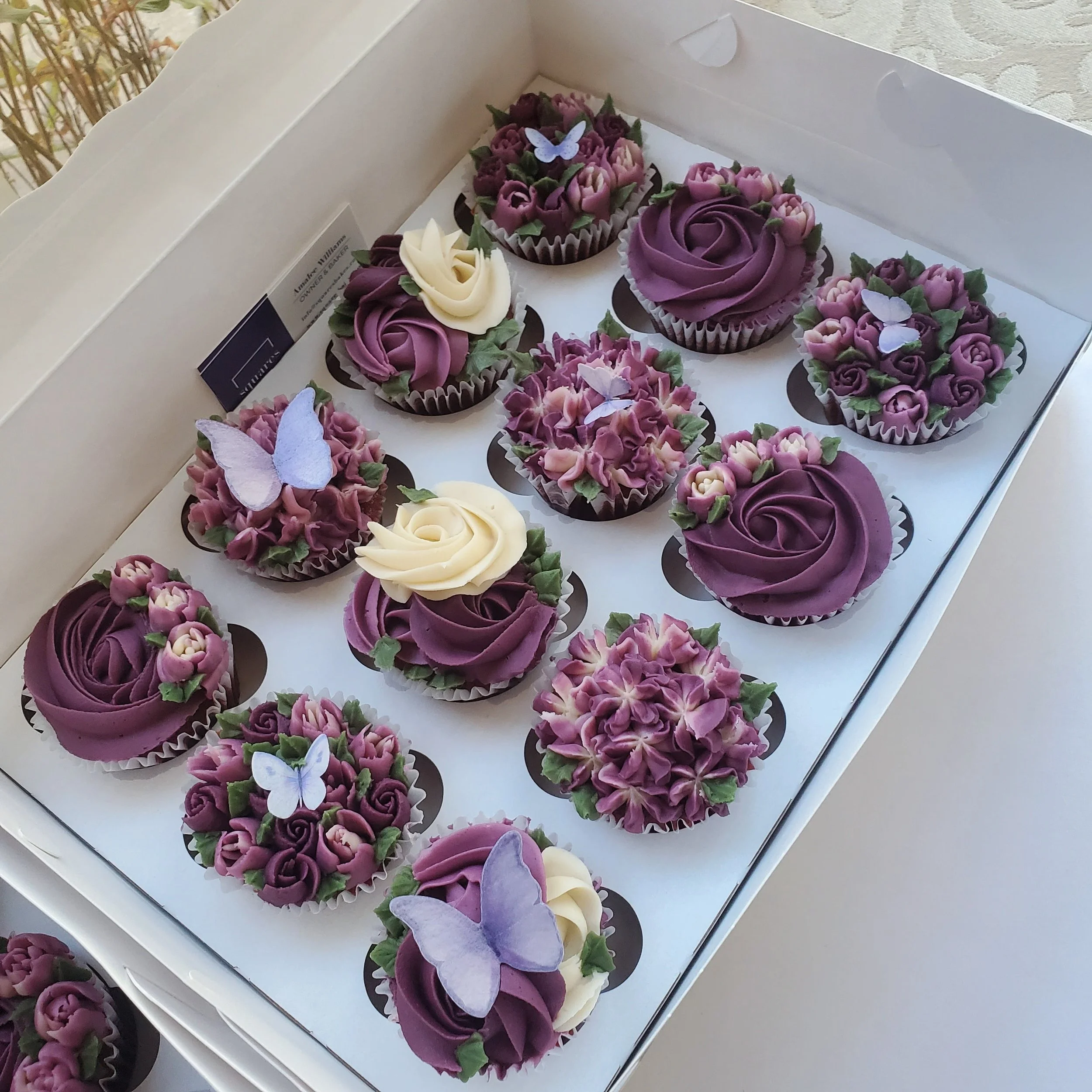 cupcakes with purple mauve buttercream flowers and butterflies