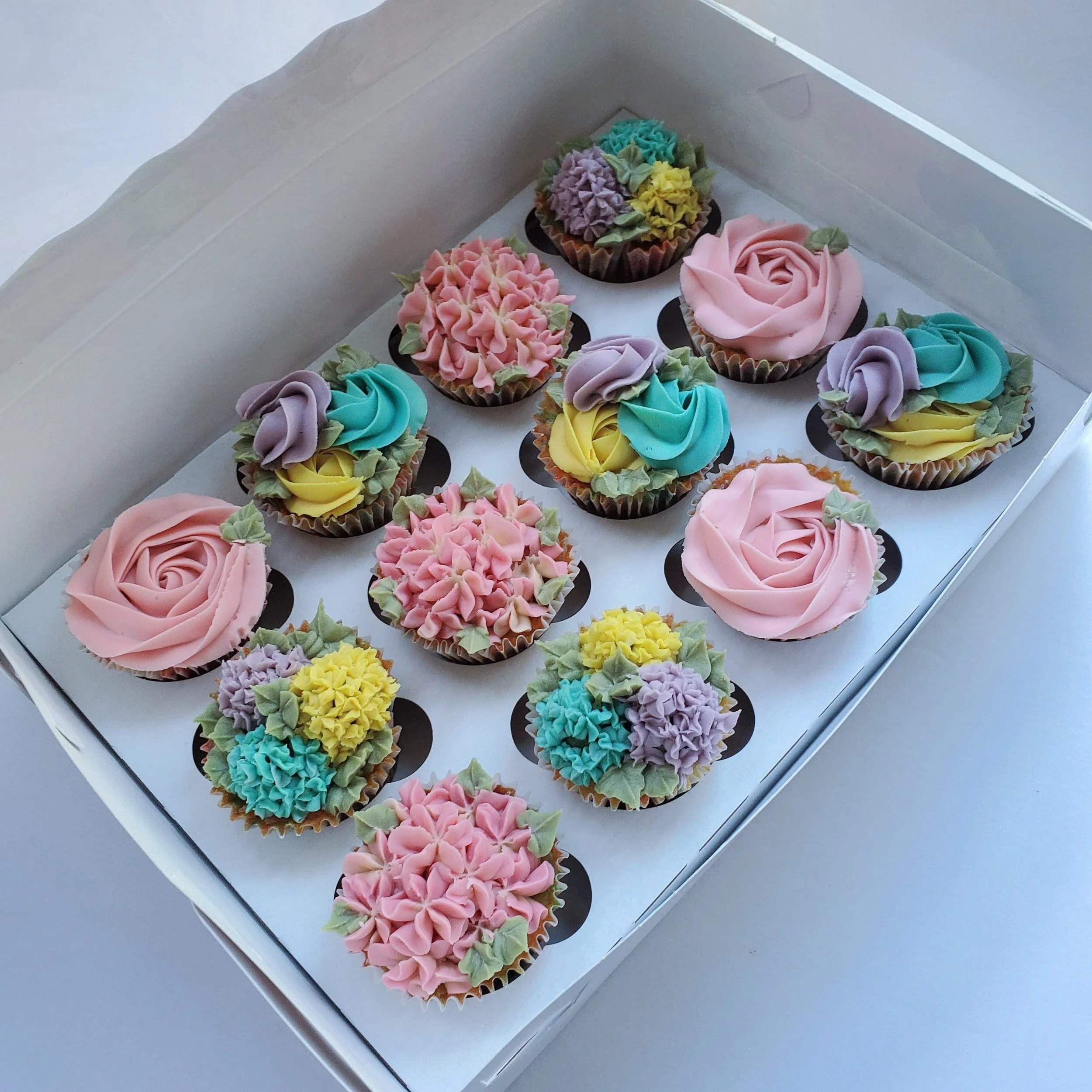 pastel pink, blue, purple, and yellow floral cupcakes
