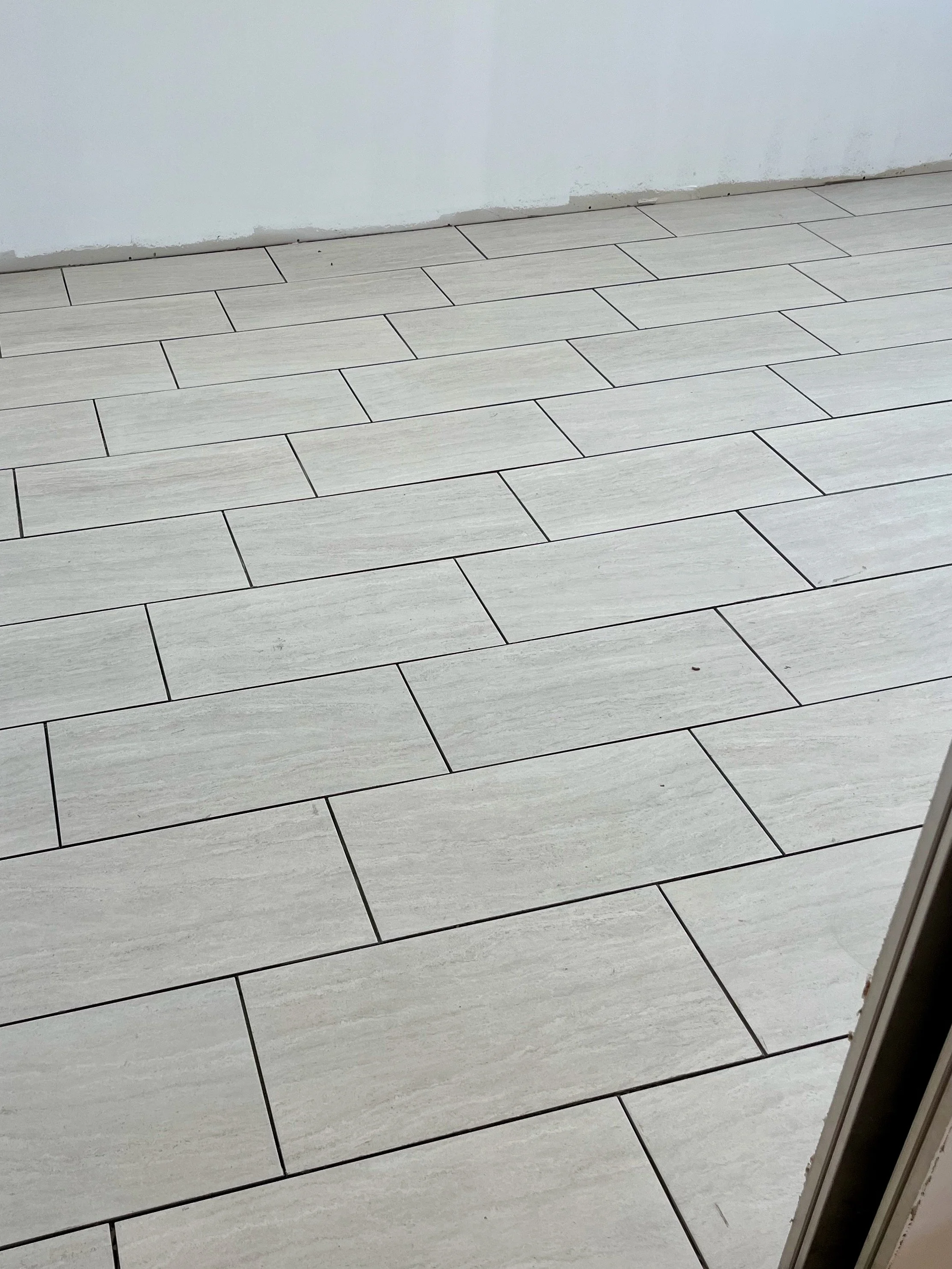 Finished tile floor installation in a room.