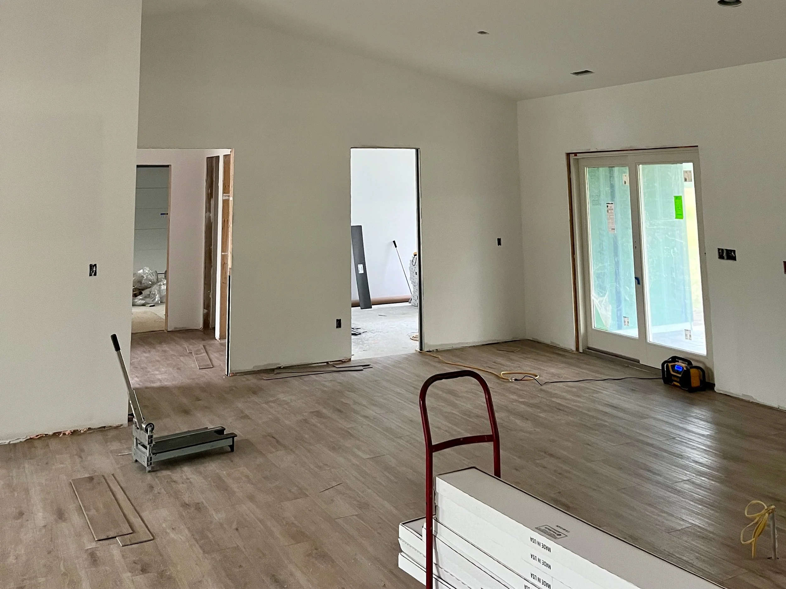 LVP flooring is being installed in an empty living space.