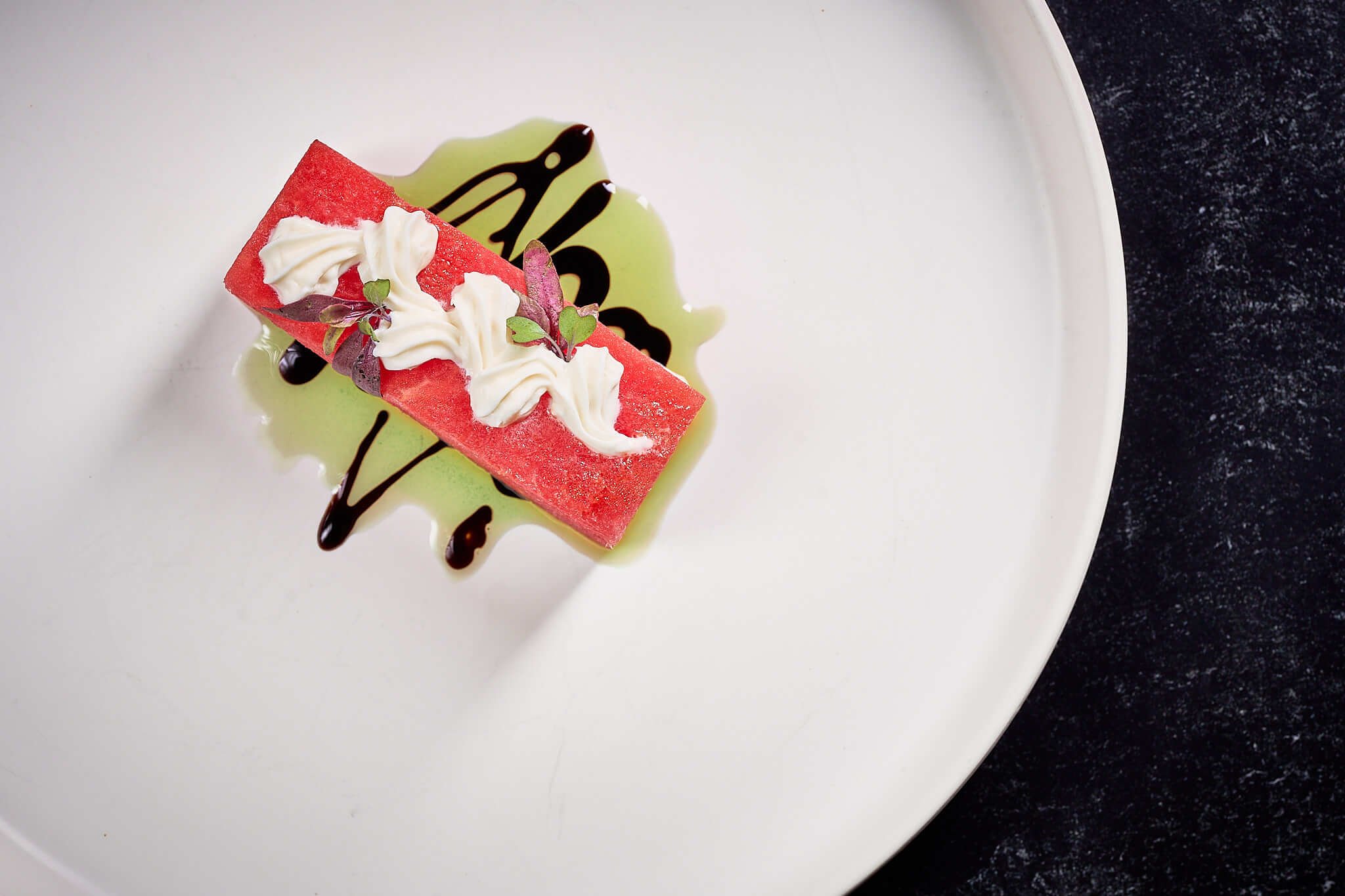 Plated Fresh Compressed Watermelon, Feta Cream, Balsamic Syrup, Basil Oil, Micro Mizuna, Nasturtium Petals created by Private Chef in Chicago, David de Quay
