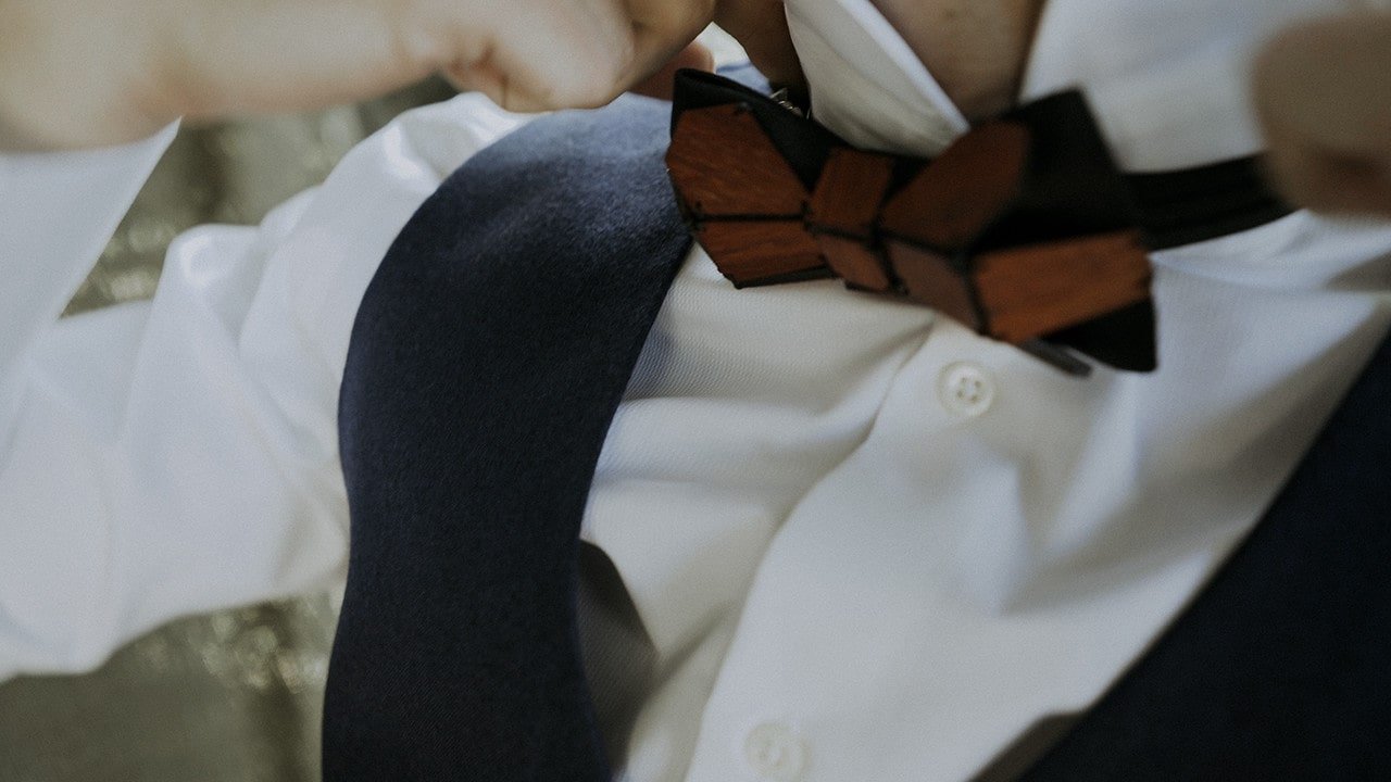 foto close up kemeja putih dasi kupu-kupu merah dan rompi angkatan laut untuk pernikahan