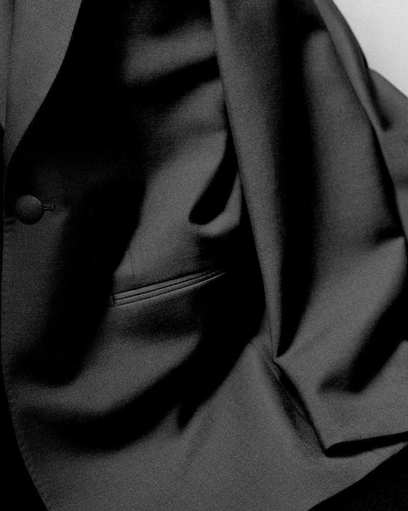 Bahan jas hitam berkualitas tinggi dengan kancing dan celah saku