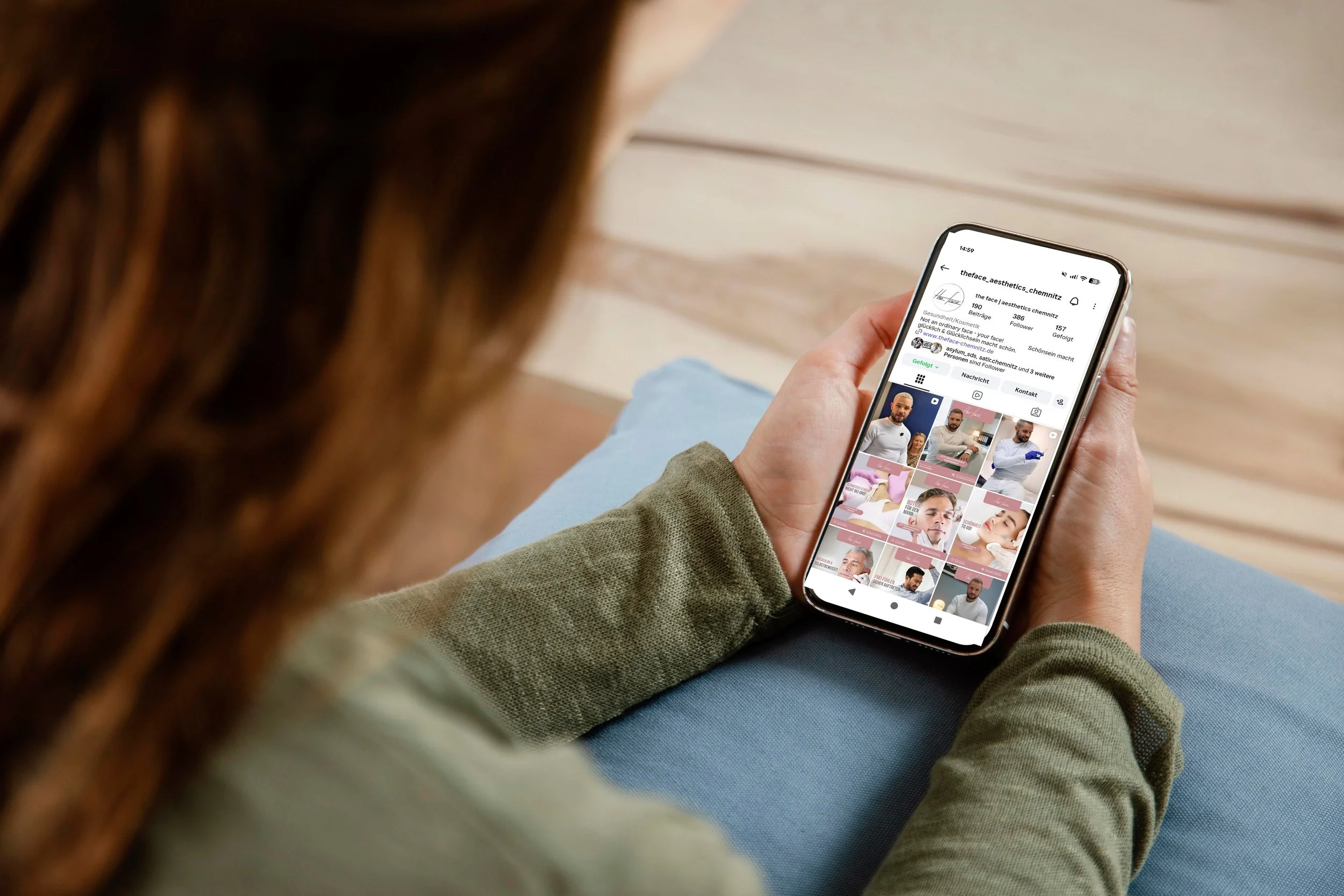 Person schaut auf ein Smartphone mit Instagram-Profil und Fotogalerie.