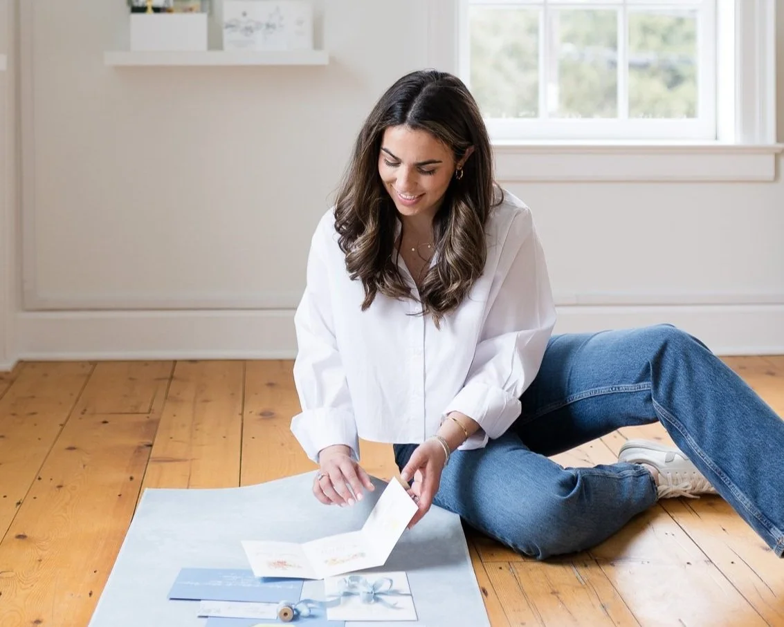 A woman with long brown hair looking at stationery samples in an office
