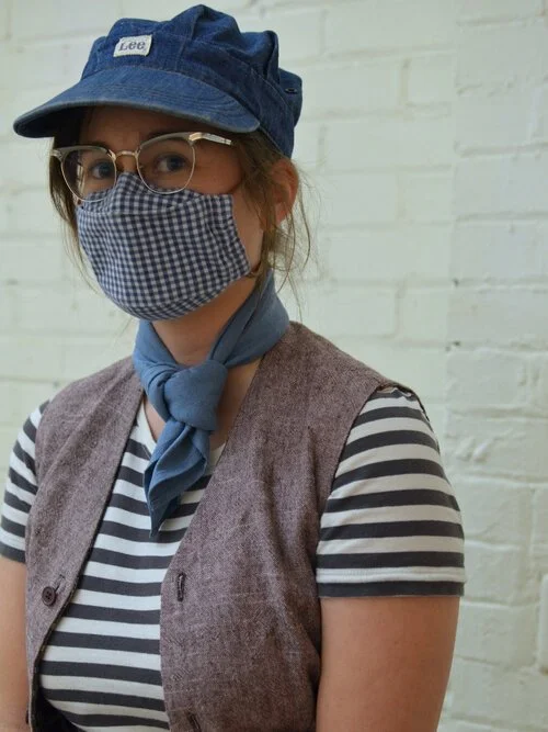 One of our team members wearing a blue and white checked face mask for health