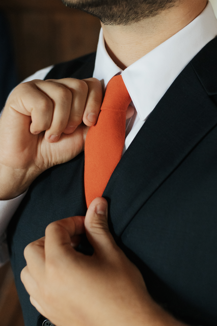 Close up detail of a lovely custom bowtie being adjusted  while worn. Bowtie is made from a favorite green birdseye fabric.