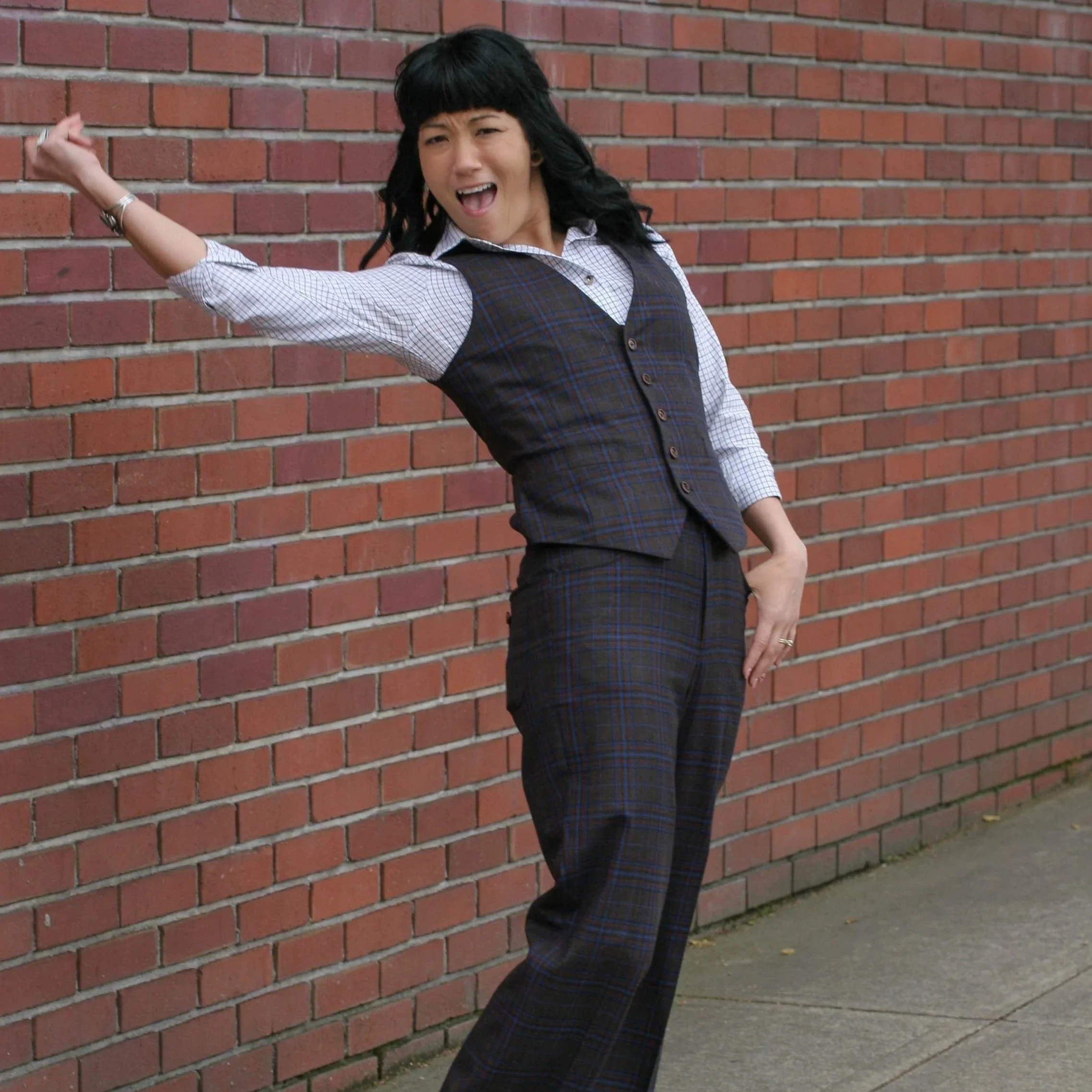 Katie smiles gently with her head tilted, rocking a buttercup yellow blazer