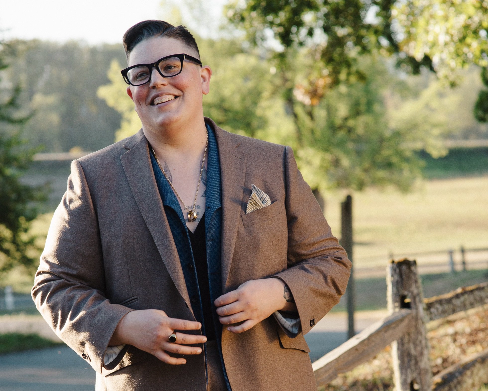 We caught Foley mid-laugh, sporting their signature black-frame glasses and a fetching brown suit
